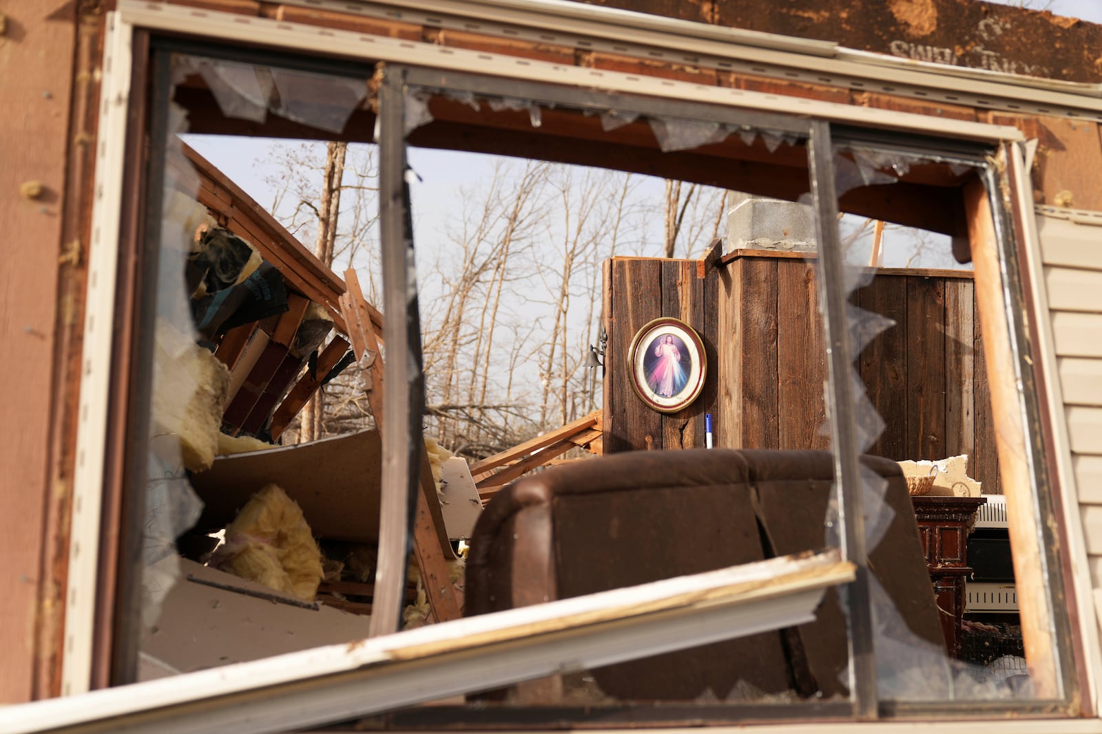 A image of Jesus hangs displayed inside a home belonging to Tim Scott, who was standing near the image when his house was destroyed by a severe storm the evening before, Saturday, March 15, 2025, in Wayne County, Mo. (AP Photo/Jeff Roberson)