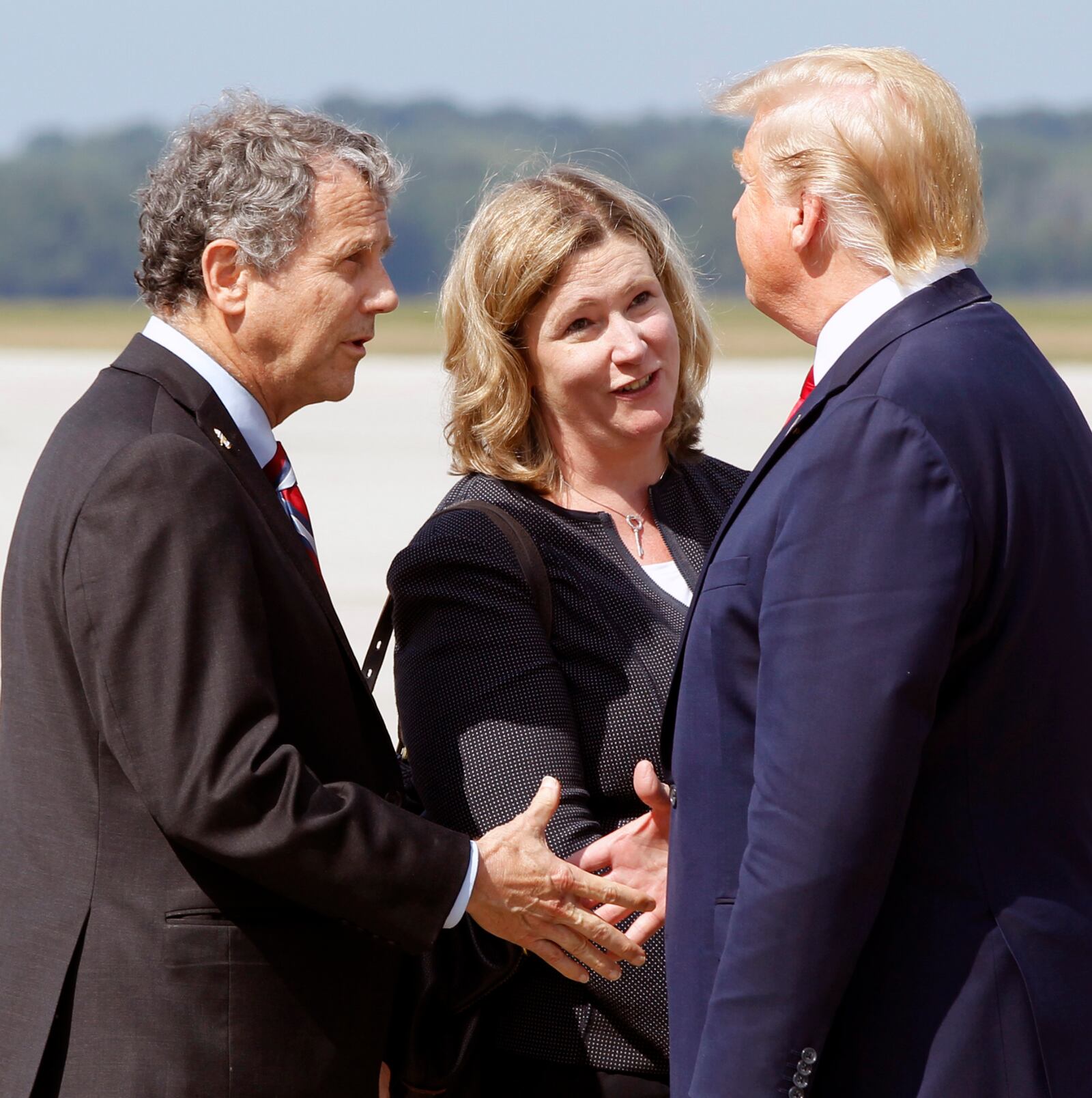 Ohio Senator Sherrod Brown (D) and Dayton Mayor Nan Whaley are greeted by President Trump at Wright-Patterson Air Force Base, Wednesday, Aug. 7, 2019, in Dayton, Ohio. Trump is in Dayton to visit with families of victims of the mass shooting that took place here on Sunday.(Ty Greenlees/Dayton Daily News/pool)