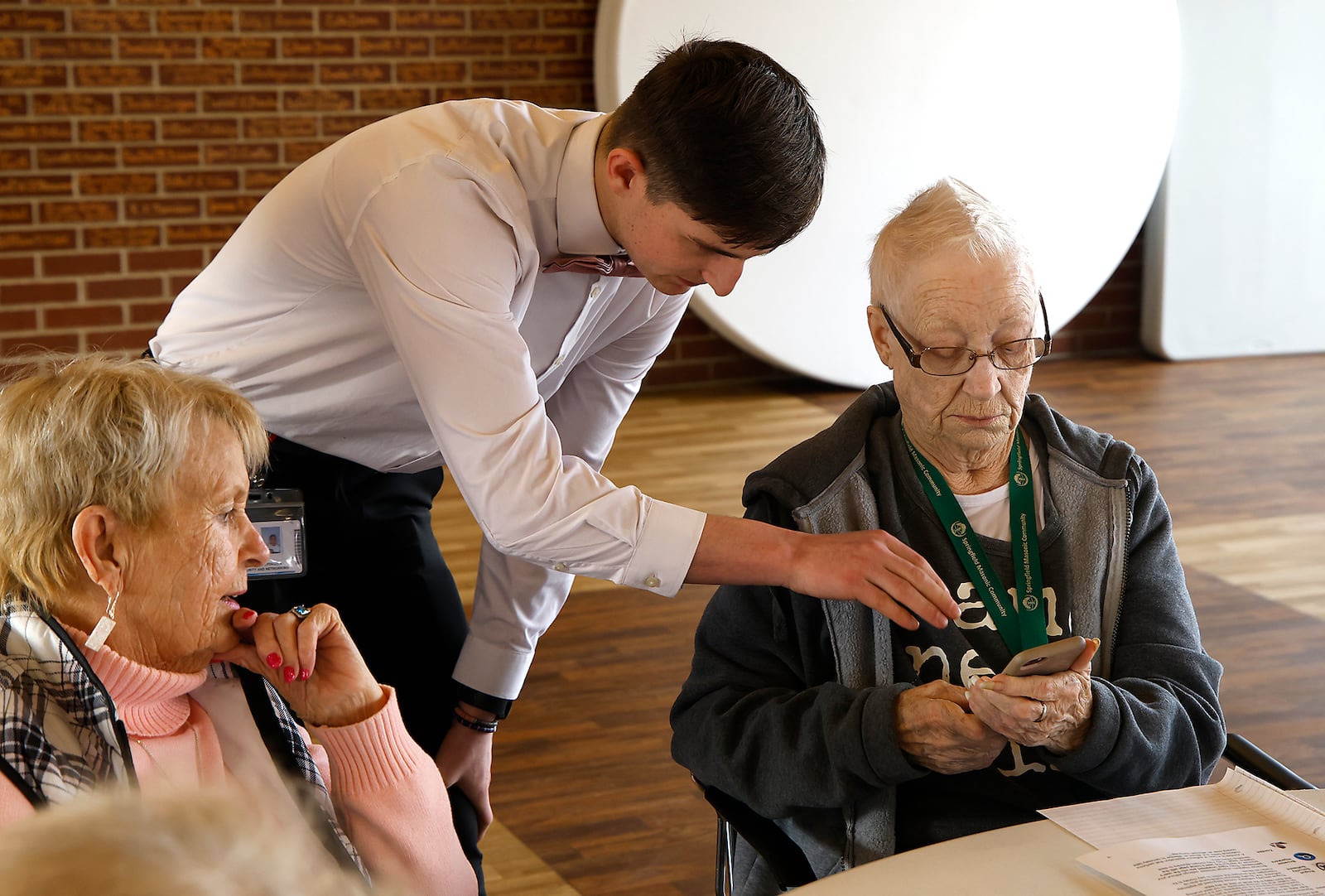 Zachary Swearingen, a senior from the Springfield/Clark CTC, helps Jeanne Seibel, a resident of the Springfield Masonic Community, with her phone Friday, Feb. 23, 2024. Zachary and several other Cyber Security students from CTC were at the Masonic Community to help the seniors with technology. BILL LACKEY/STAFF