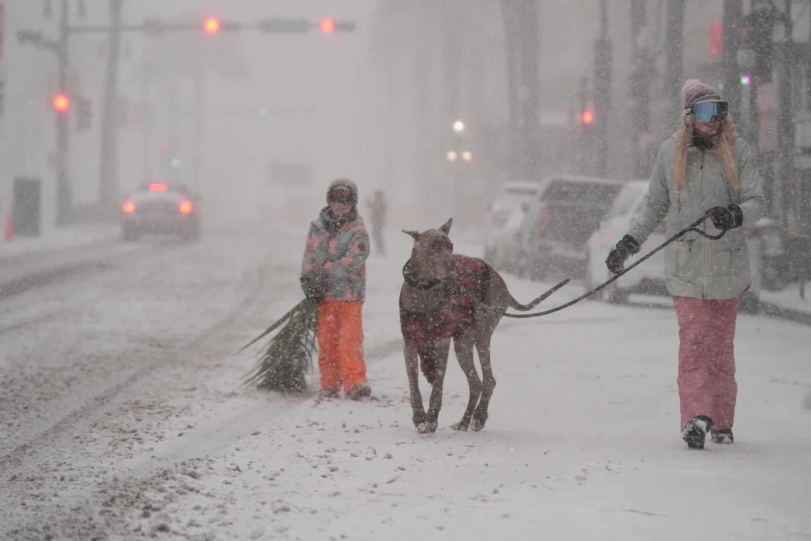 Kristyn Tramel walks her dog Bluey with her 8-year-old son Penn in the French Quarter is seen in New Orleans, Tuesday, Jan. 21, 2025. (AP Photo/Gerald Herbert)