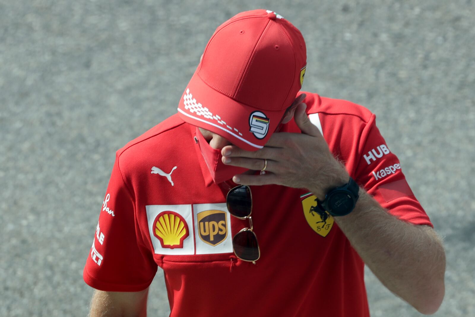 Ferrari driver Sebastian Vettel of Germany touches his face as he walks in the pit lane prior to the Italian Formula One Grand Prix, at the Monza racetrack in Monza, Italy, Sunday Sept. 6, 2020. (AP Photo/Luca Bruno, Pool)