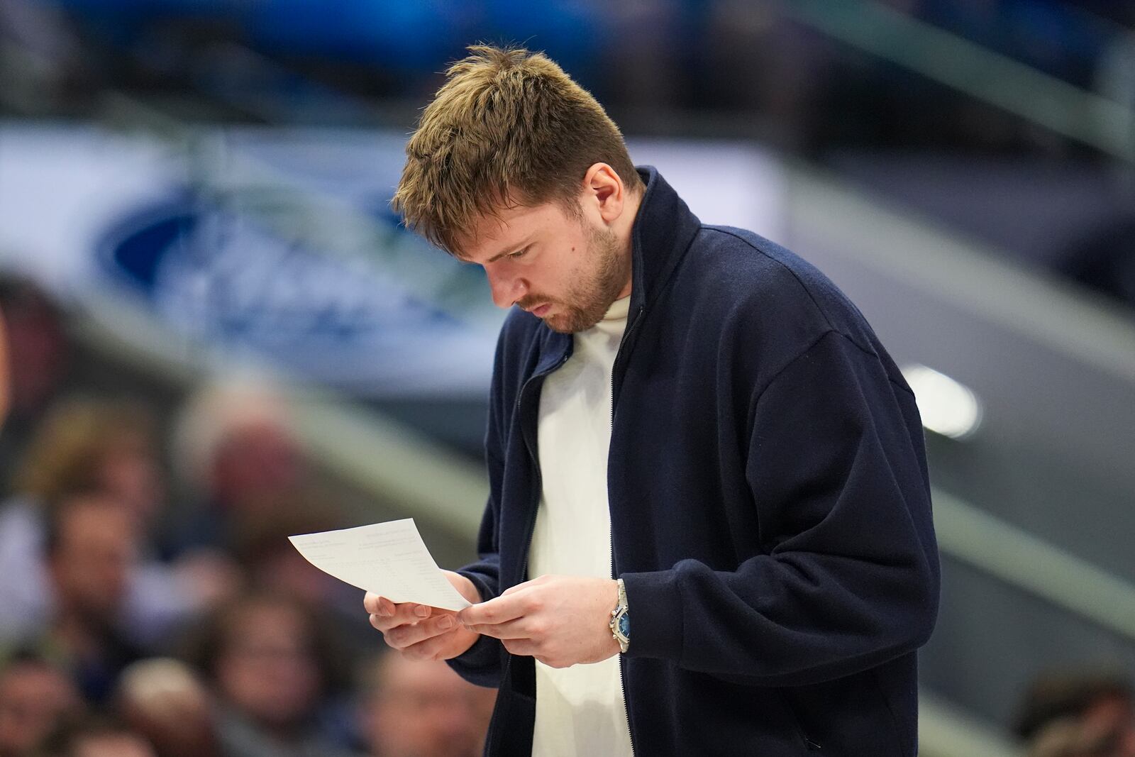 Dallas Mavericks guard Luka Doncic looks over notes during a timeout in the first half of an NBA basketball game against the Denver Nuggets, Sunday, Jan. 12, 2025, in Dallas. (AP Photo/Julio Cortez)