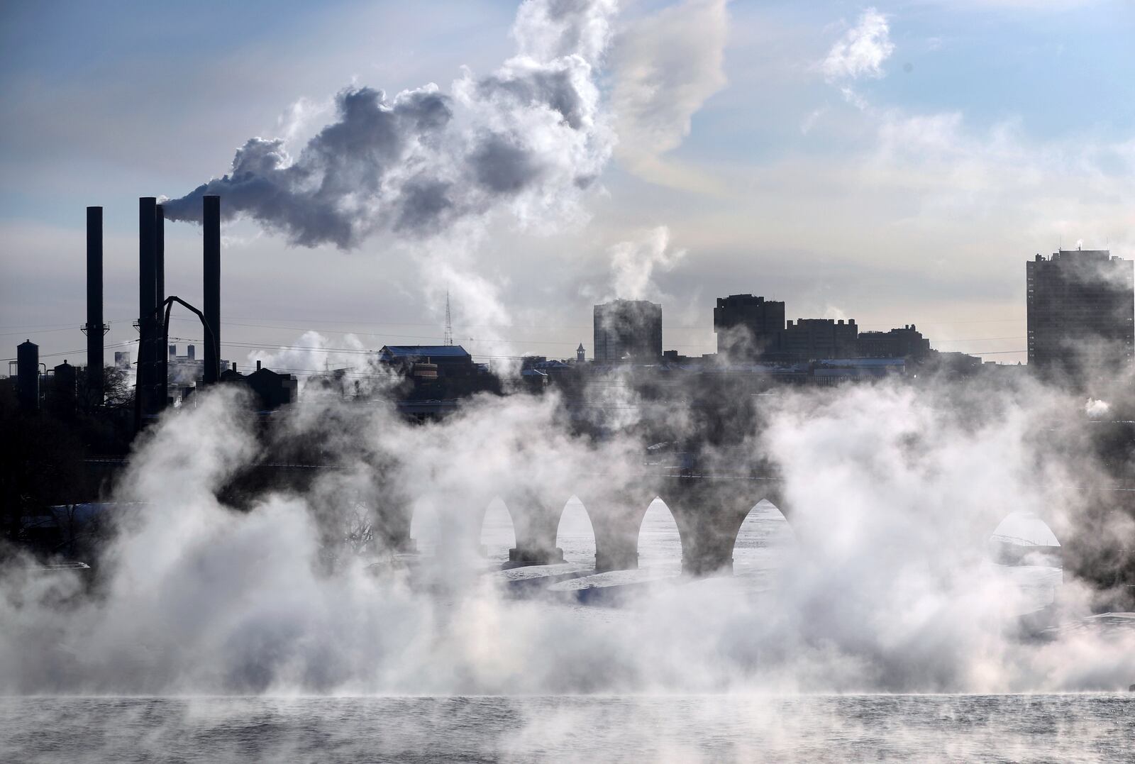 FILE - Water vapor rises above St. Anthony Falls on the Mississippi River as the Stone Arch Bridge is obscured, seen from the Third Ave. Bridge Jan. 29, 2019, In Minneapolis. (David Joles/Star Tribune via AP)