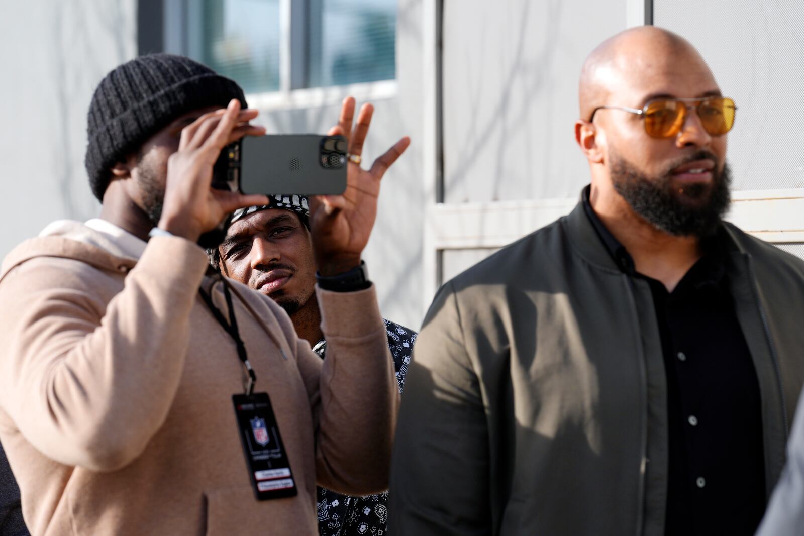 Retired NFL player T.J. Wright, second from left, watches footage on NFL player Charles Harris' phone as retired NFL player Copeland Bryan, right, acts out a scene from the film "Meet the Blacks" during a filmmaking workshop for NFL players on Tuesday, March 4, 2025, in Santa Monica, Calif. (AP Photo/Chris Pizzello)