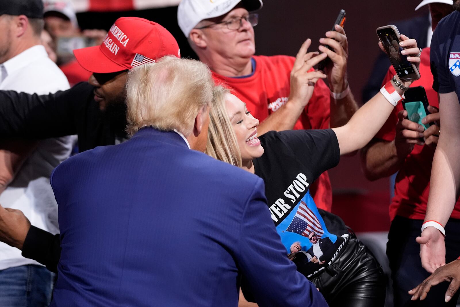 Republican presidential nominee former President Donald Trump poses for a photo with a supporter at a campaign event at the Cobb Energy Performing Arts Centre, Tuesday, Oct. 15, 2024, in Atlanta. (AP Photo/Alex Brandon)