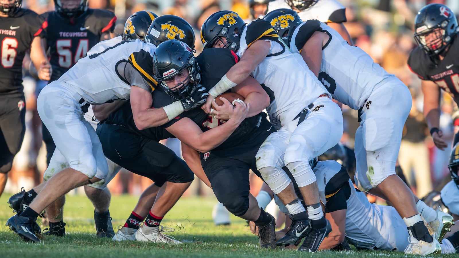 Tecumseh High School senior Connor Bledsoe is tackled by a group of Shawnee defenders during their game on Friday night at Spitzer Stadium in New Carlisle. The Braves won 42-14. Michael Cooper/CONTRIBUTED