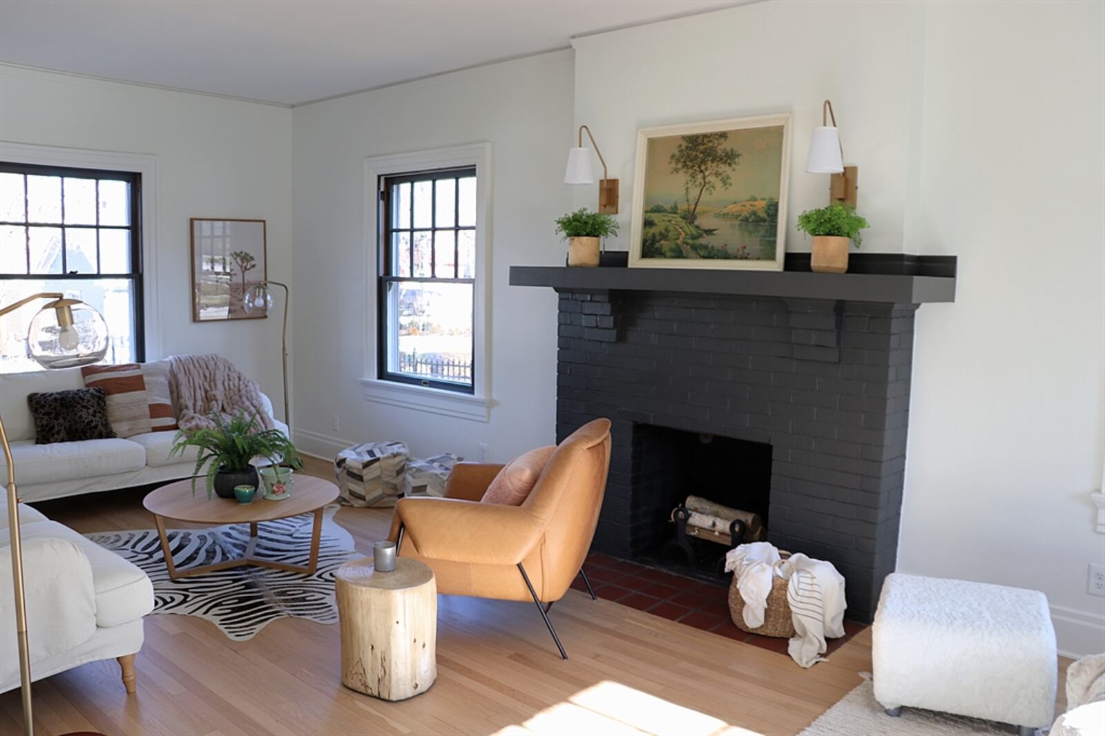 A painted brick fireplace, with a wooden mantel and terra cotta hearth, is the centerpiece to the living room.