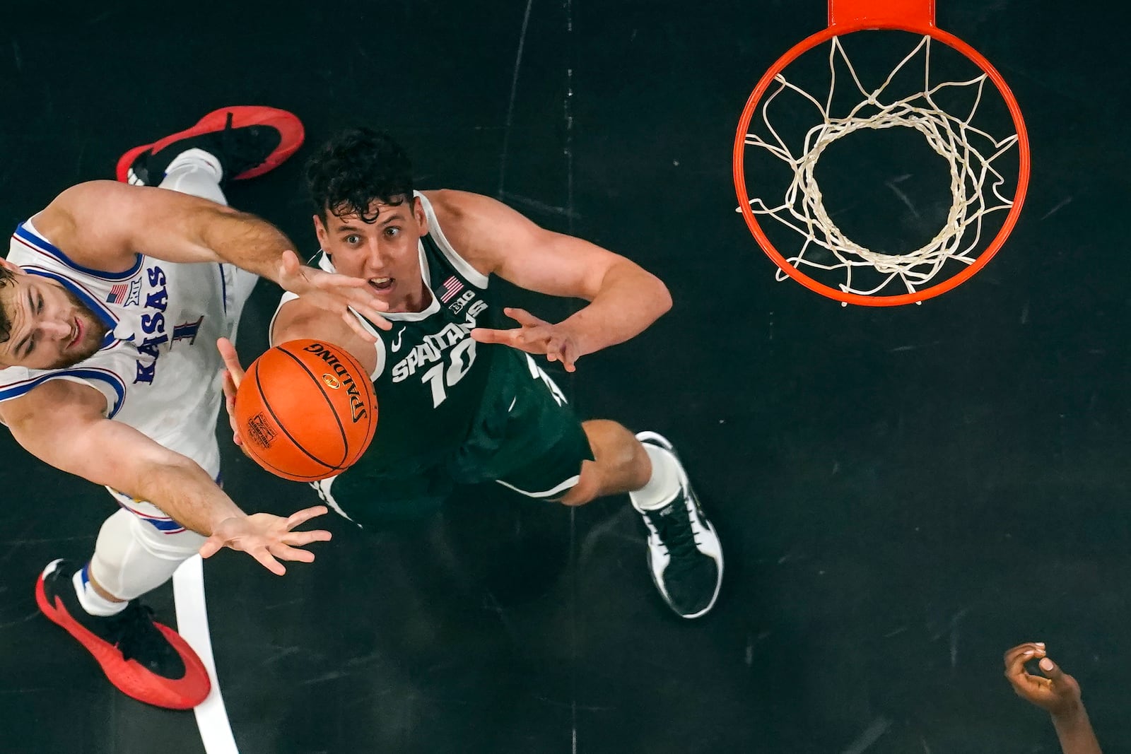 Kansas center Hunter Dickinson (1) and Michigan State center Szymon Zapala (10) battle for a rebound during the first half of an NCAA college basketball game, Tuesday, Nov. 12, 2024, in Atlanta. (AP Photo/John Bazemore )