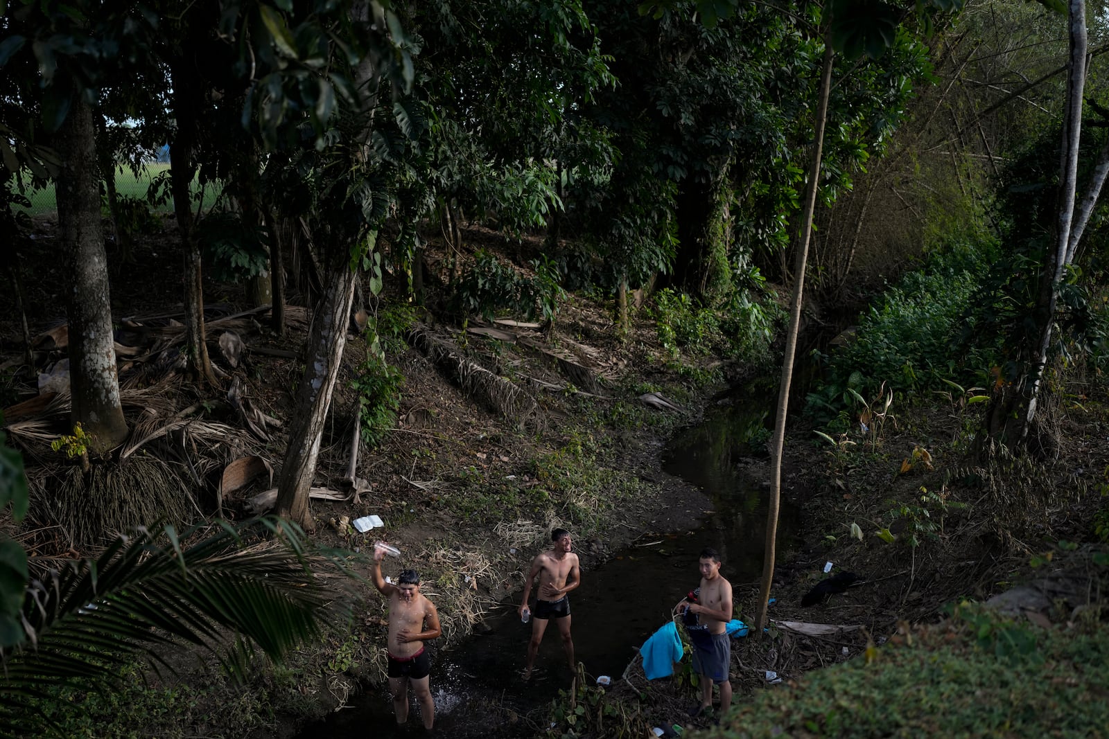 Venezuelan migrants bathe themselves in a river in Panama City, Sunday, March 2, 2025. The migrants are returning from southern Mexico after giving up on reaching the U.S., a reverse flow triggered by the Trump administration's immigration crackdown. (AP Photo/Matias Delacroix)