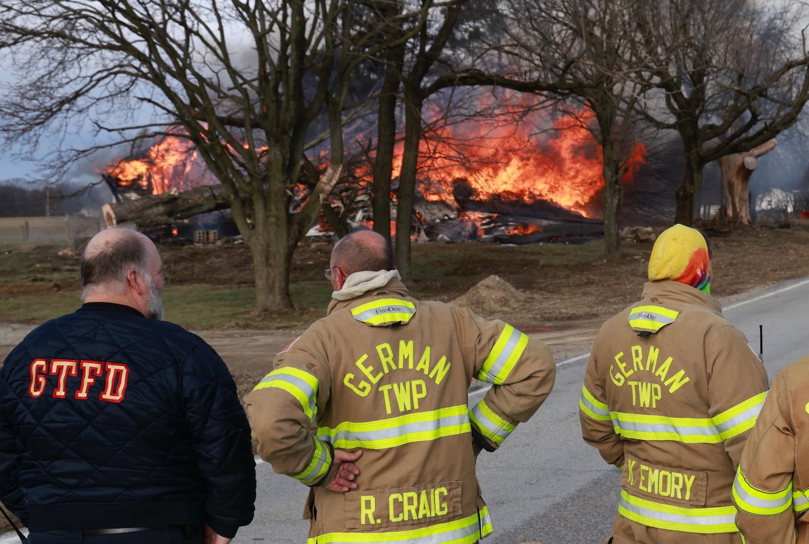 German Township firefighters watch as a house burns Monday, Dec. 23, 2024. The house on Ballentine Pike was deliberately set by the owner to demolish the house. BILL LACKEY/STAFF