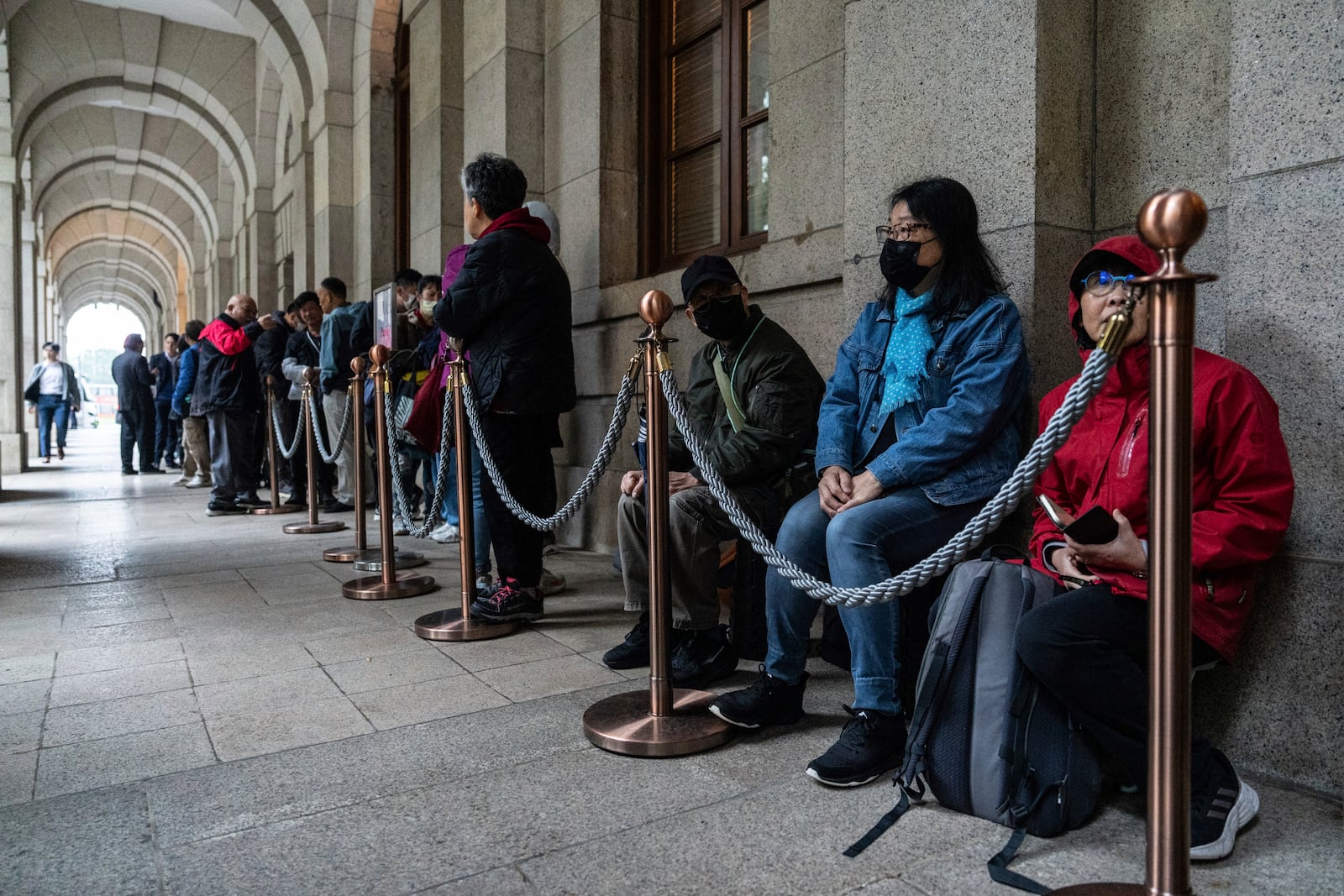 People wait in line outside the Court of Final Appeal in Hong Kong, Thursday, March 6, 2025. Three former organizers of Hong Kong's annual vigil in remembrance of the 1989 Tiananmen Square crackdown won their bid at the top court on Thursday to overturn their conviction over their refusal to provide information to police, marking a rare victory for the city's pro-democracy activists. (AP Photo/Chan Long Hei)