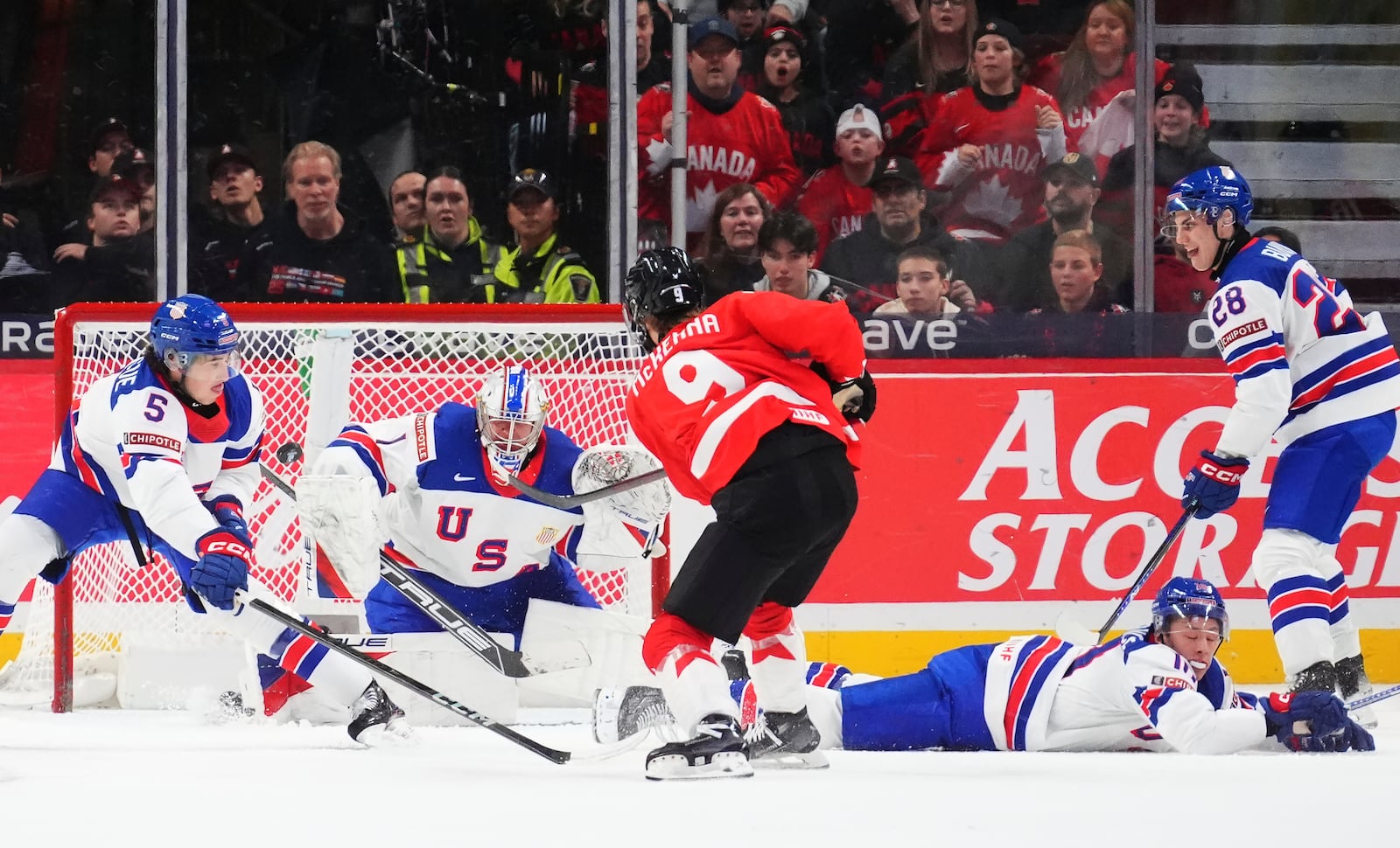 United States goaltender Trey Augustine (1) makes a save against Canada's Gavin McKenna (9) as United States' Drew Fortescue (5) defends during third-period IIHF World Junior Hockey Championship tournament game action in Ottawa, Ontario, Tuesday, Dec. 31, 2024. (Sean Kilpatrick/The Canadian Press via AP)