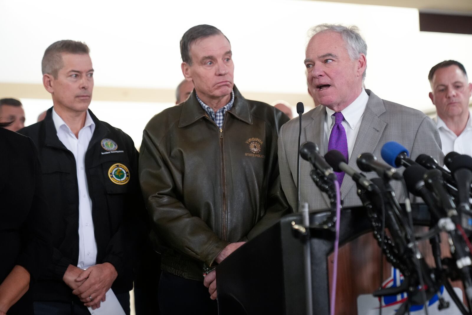 From left, Transportation Secretary Sean Duffy, Sen. Mark Warner, D-Va. and Sen. Tim Kaine, D-Va., and other officials, during a news conference on the Wednesday night crash of an American Airlines jet that collided with an Army helicopter, at Ronald Reagan Washington National Airport, Thursday morning, Jan. 30, 2025, in Arlington, Va. (AP Photo/Mark Schiefelbein)