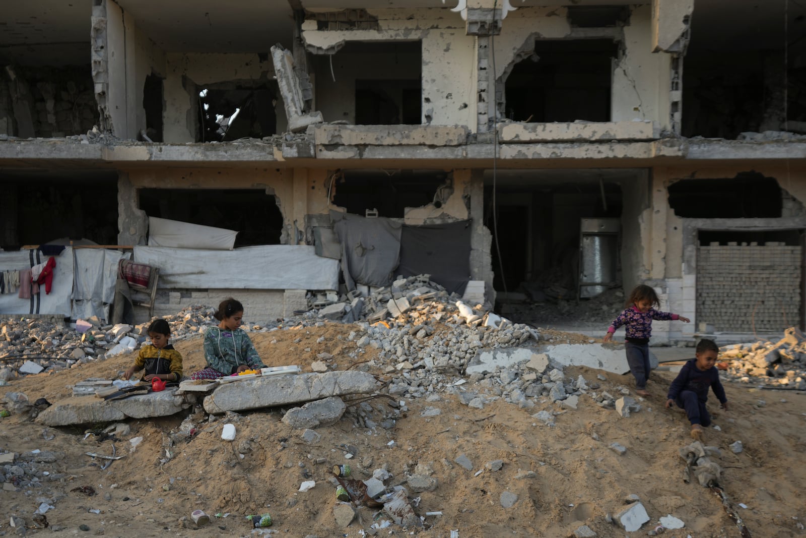 Palestinian children play on the rubble of destroyed buildings at a neighbourhood in Khan Younis, Gaza Strip, Sunday, Dec. 1, 2024. (AP Photo/Abdel Kareem Hana)