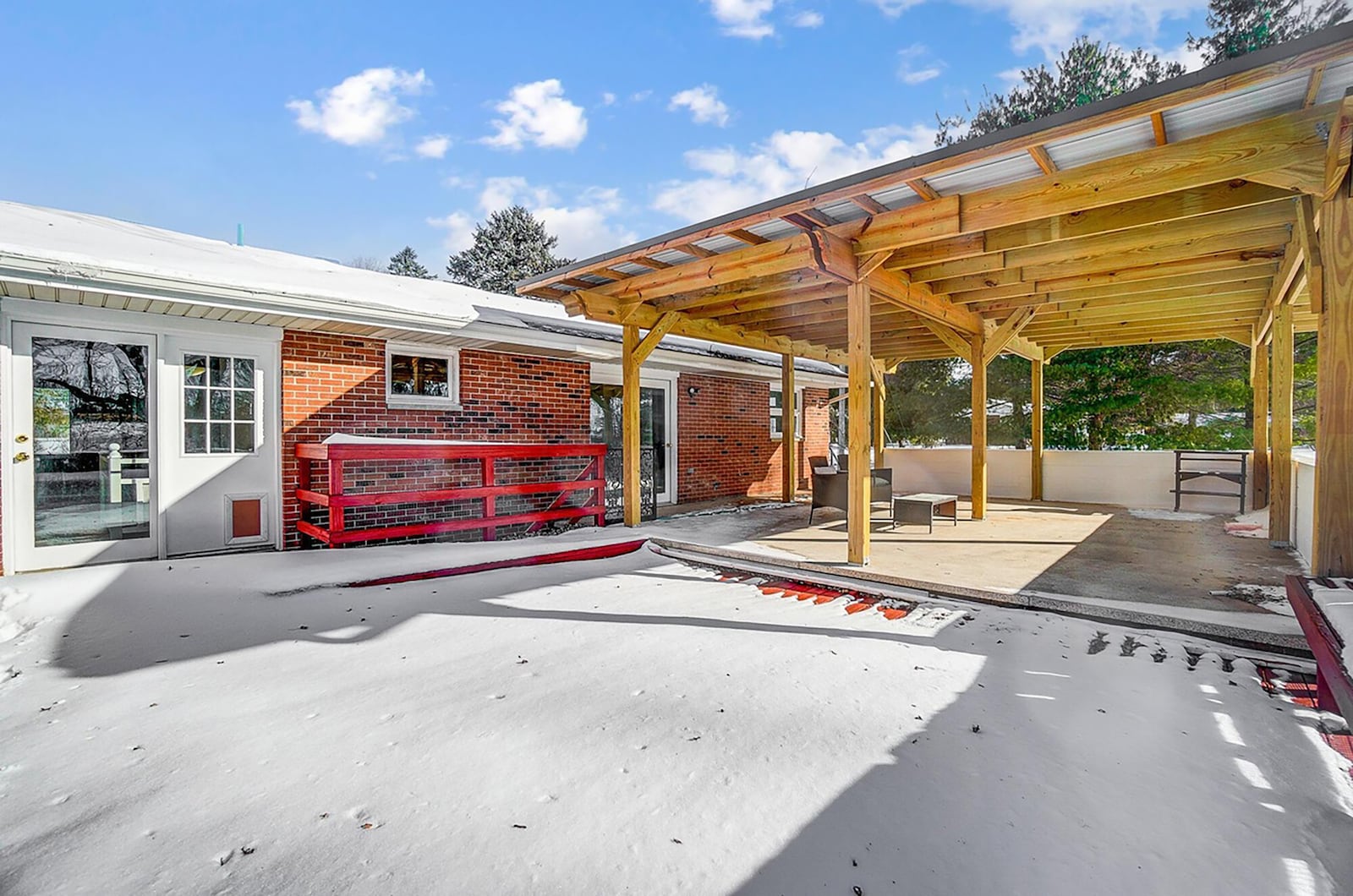 The rear of the home has a concrete patio and wood deck with railing. The primary steps out to the patio covered with a wood pergola.