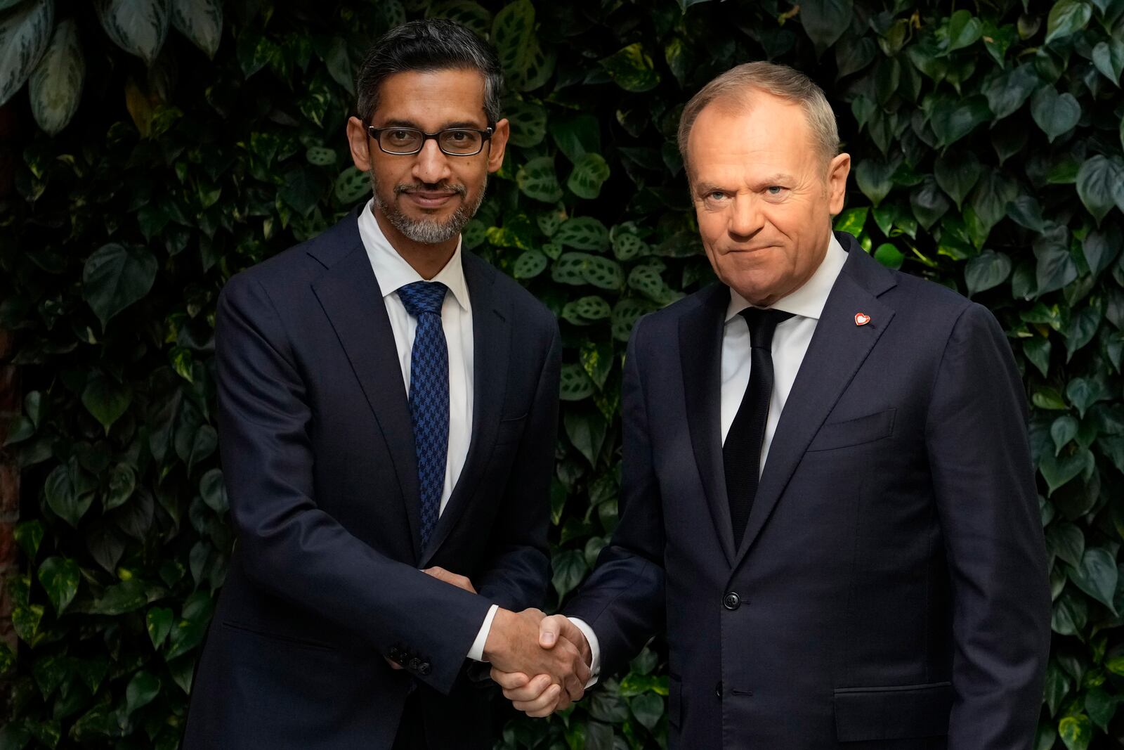 Google and Alphabet CEO Sundar Pichai, left, and Poland's Prime Minister Donald Tusk, right, meet for talks about involving artificial intelligence into the energy and cybersecurity sectors in Poland, at the Google Startup Campus in Warsaw, Poland, on Thursday, Feb. 13, 2025. (AP Photo/Czarek Sokolowski)