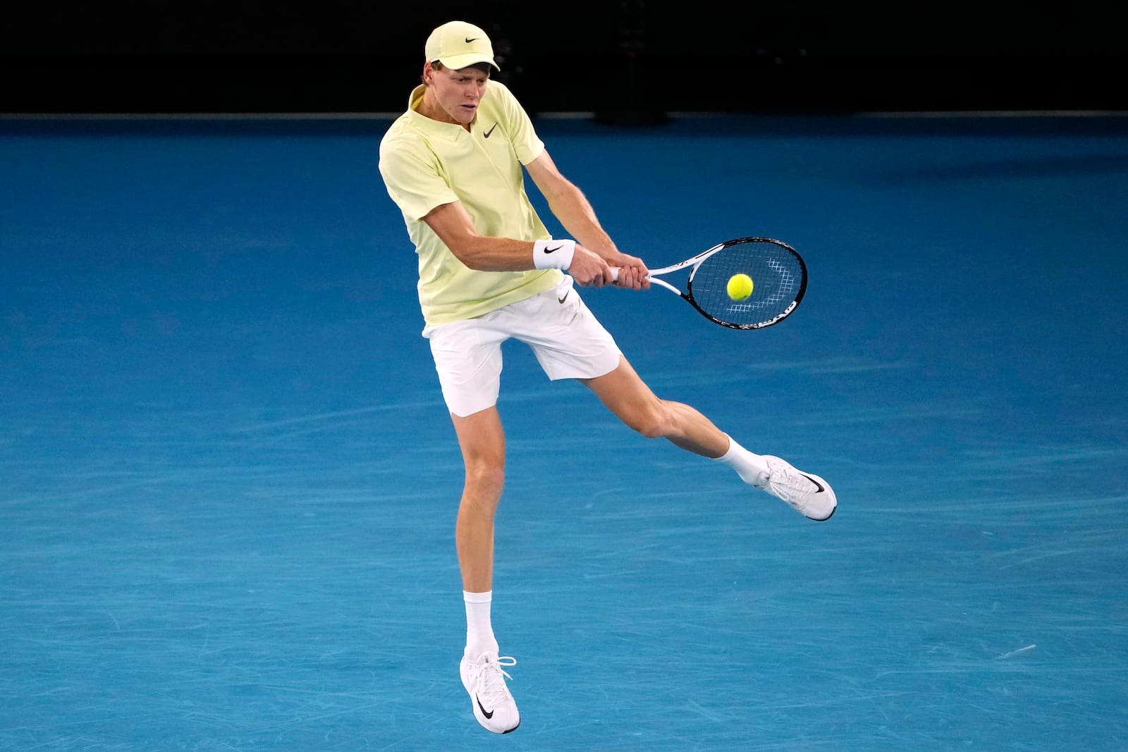 Jannik Sinner of Italy plays a backhand return to Alex de Minaur of Australia during their quarterfinal match at the Australian Open tennis championship in Melbourne, Australia, Wednesday, Jan. 22, 2025. (AP Photo/Ng Han Guan)