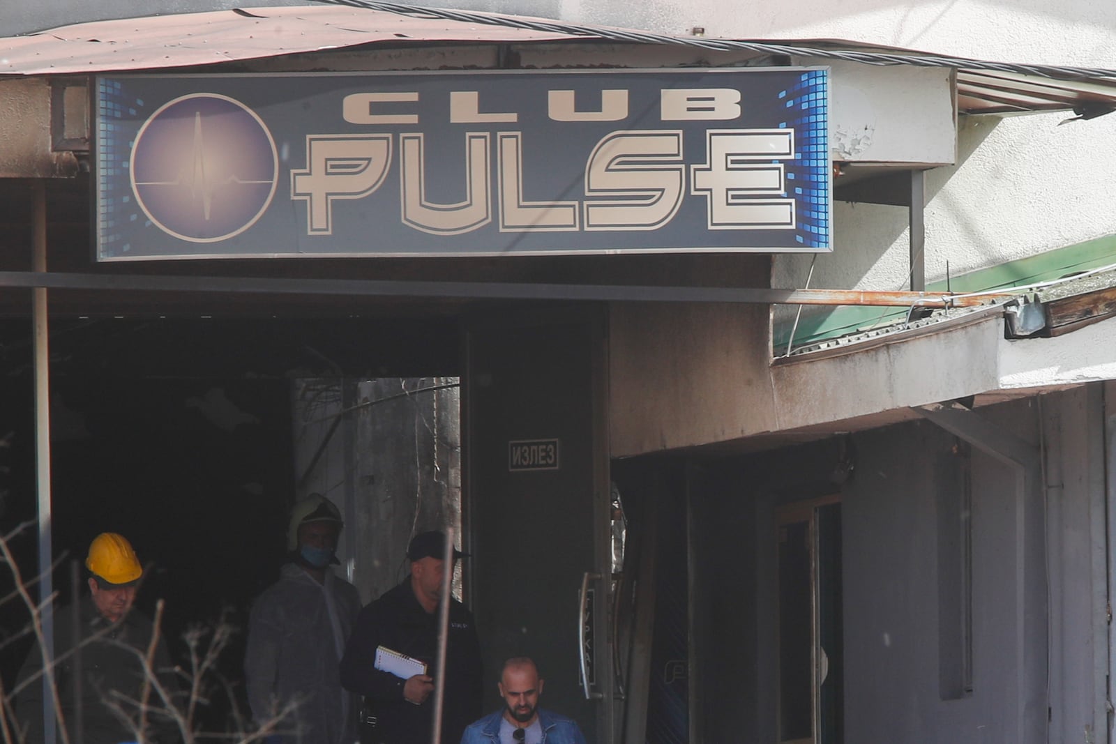 Police officers investigate a nightclub after a massive fire in the town of Kocani, North Macedonia, Sunday, March 16, 2025. (AP Photo/Boris Grdanoski)