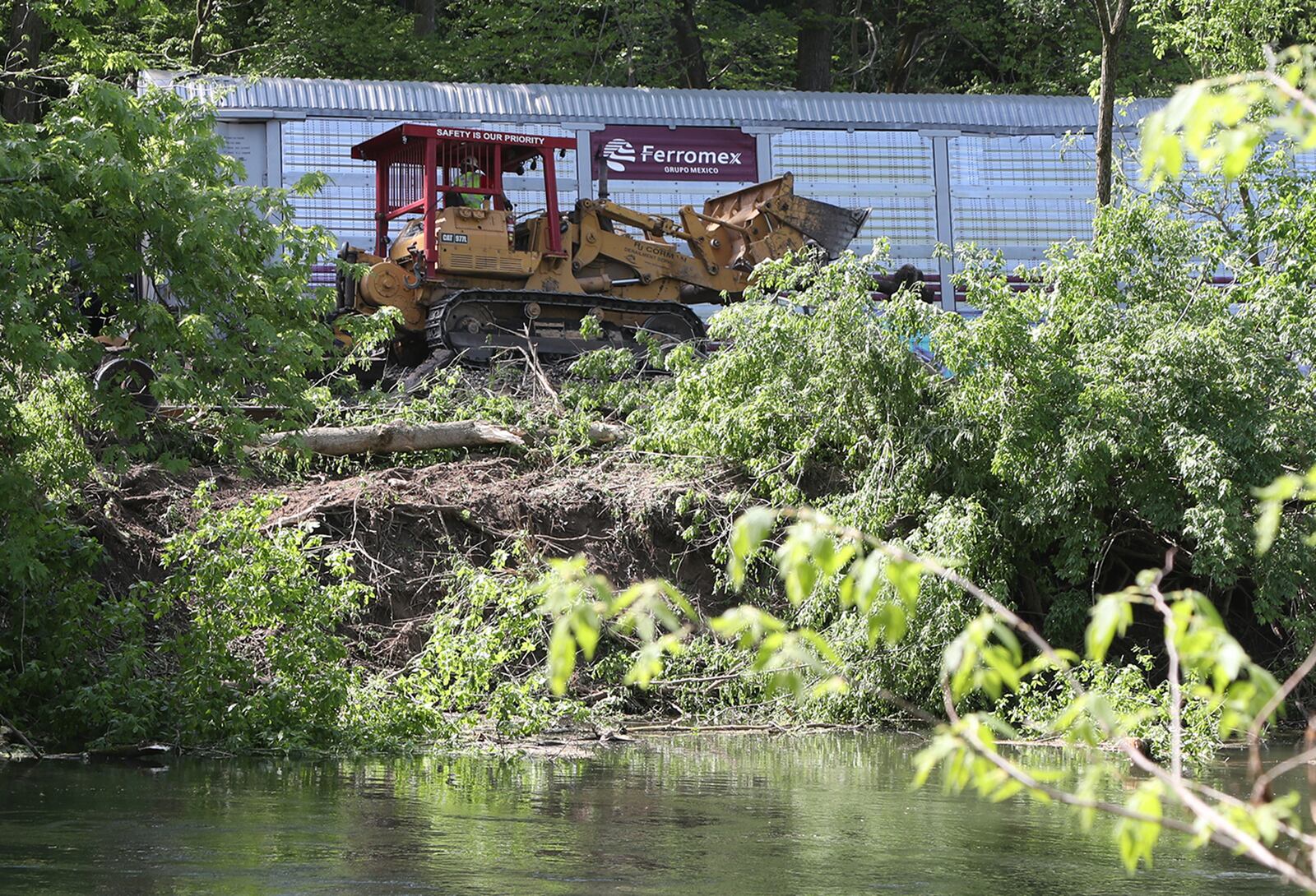 Heavy equipment is brought in to clean up after the train derailment along the Mad River Friday. BILL LACKEY/STAFF