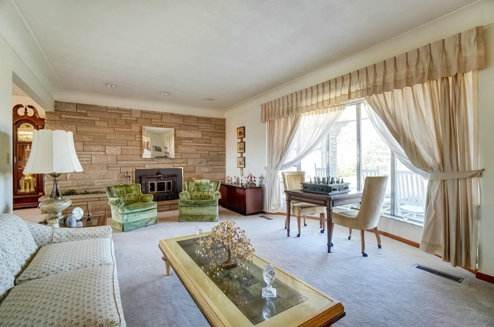 the living room has carpeting and a woodburning fireplace with stove insert.