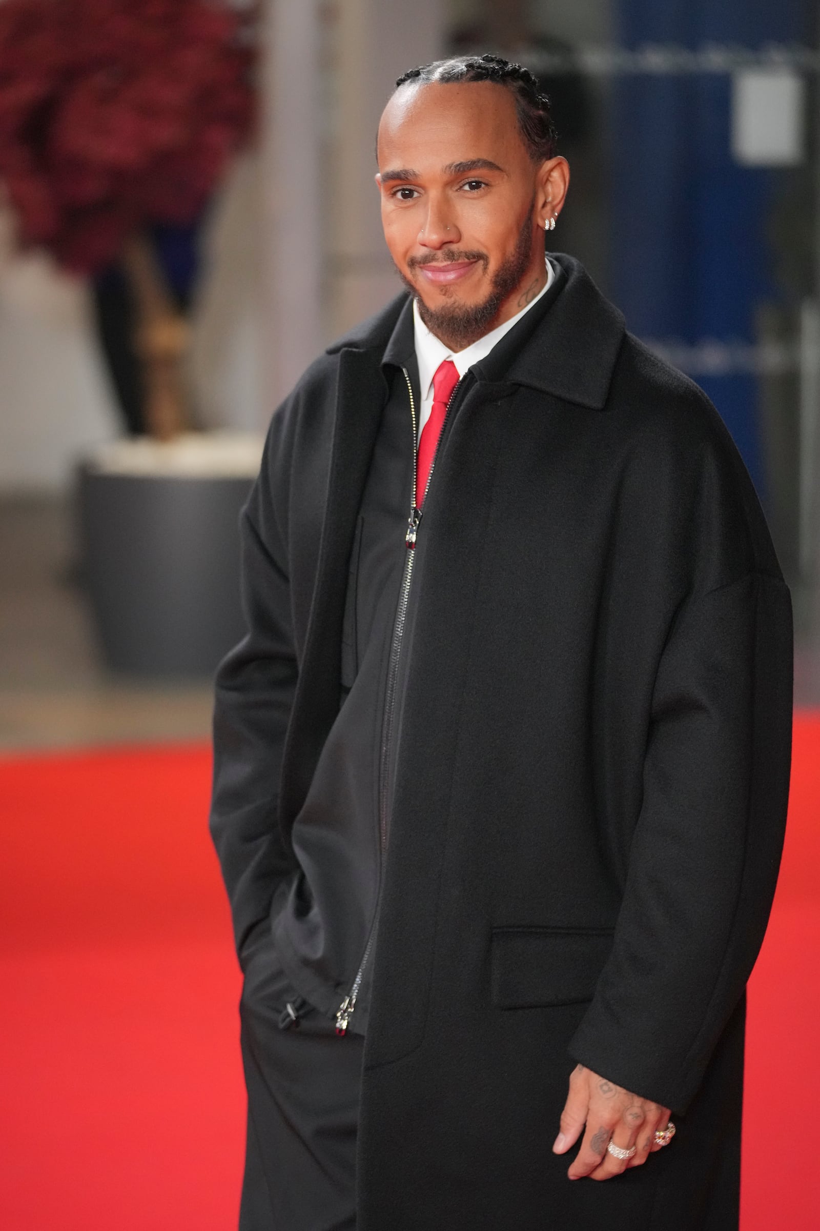 Ferrari driver Lewis Hamilton of Britain poses for cameras as he arrives to the F1@75 launch event at the O2 arena in London, Tuesday, Feb. 18, 2025. (AP Photo/Kin Cheung)