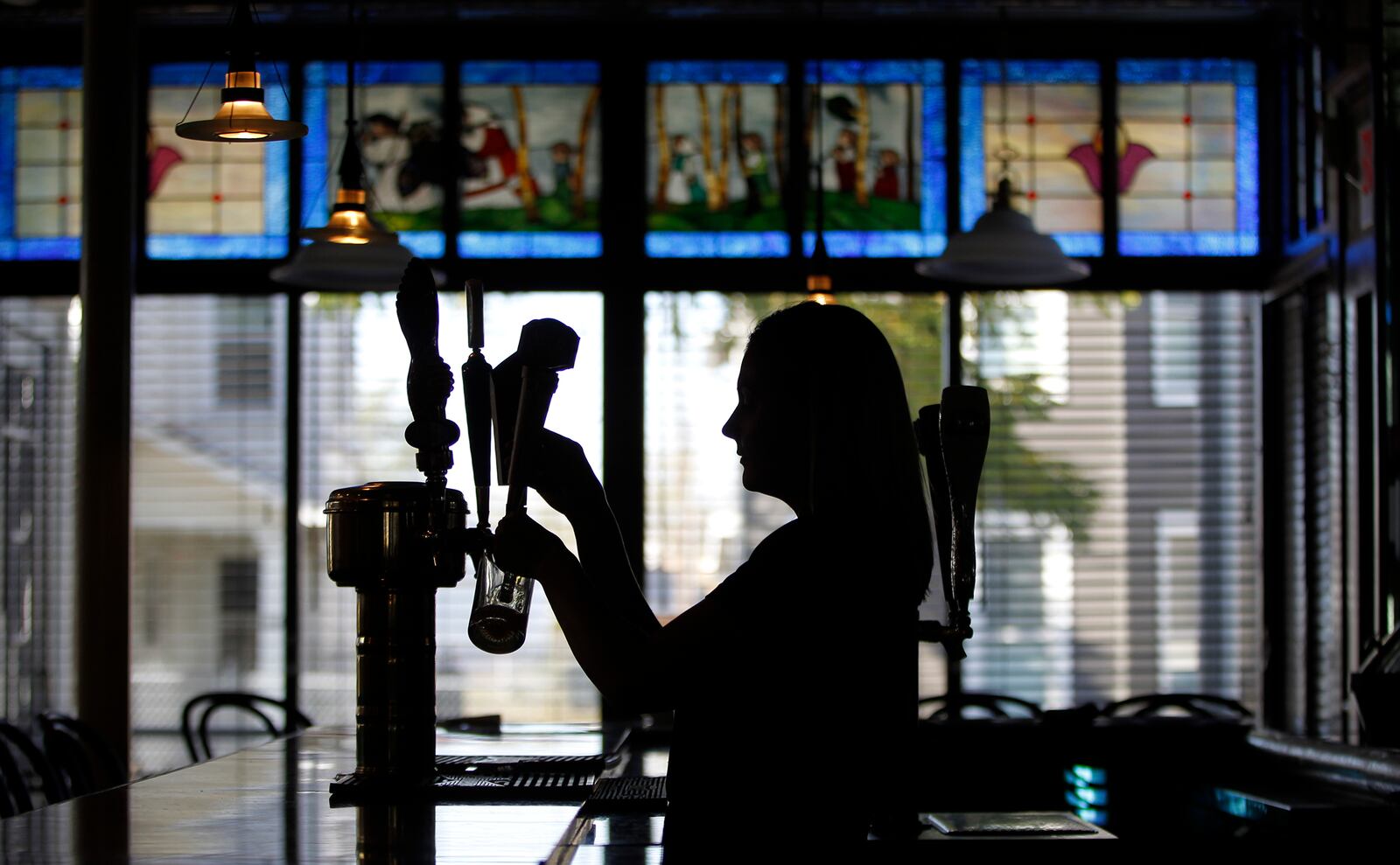 Emily Stephens, the catering manager at The Amber Rose Restaurant and Catering, a Dayton institution specializing in homemade Eastern European cuisine, pours a beer. LISA POWELL / STAFF