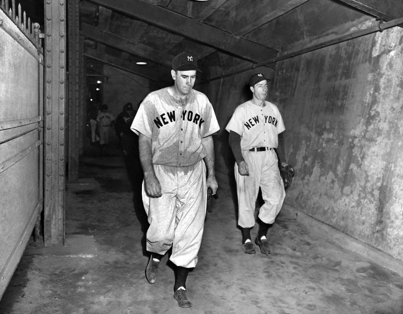 FILE - New York Yankees pitcher Bill Bevens, left, who pitched a one-hitter and lost, 3-2, and Yankees outfielder Joe DiMaggio walk down the runway leading to the clubhouse at Ebbets Field after Game 4 of the World Series against the Brooklyn Dodgers, Oct. 3, 1947. (AP Photo/John Lindsay, File)