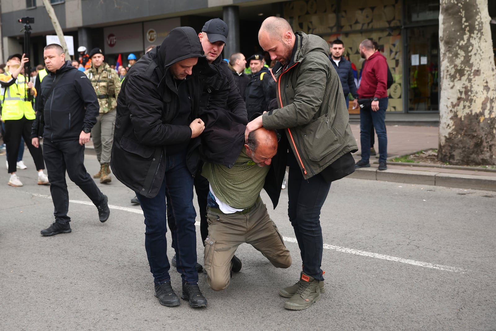 A man who allegedly claimed he was armed with bombs is detained by plain clothed police during a major rally against populist President Aleksandar Vucic and his government, in downtown Belgrade, Serbia, Saturday, March 15, 2025. (AP Photo/Armin Durgut)