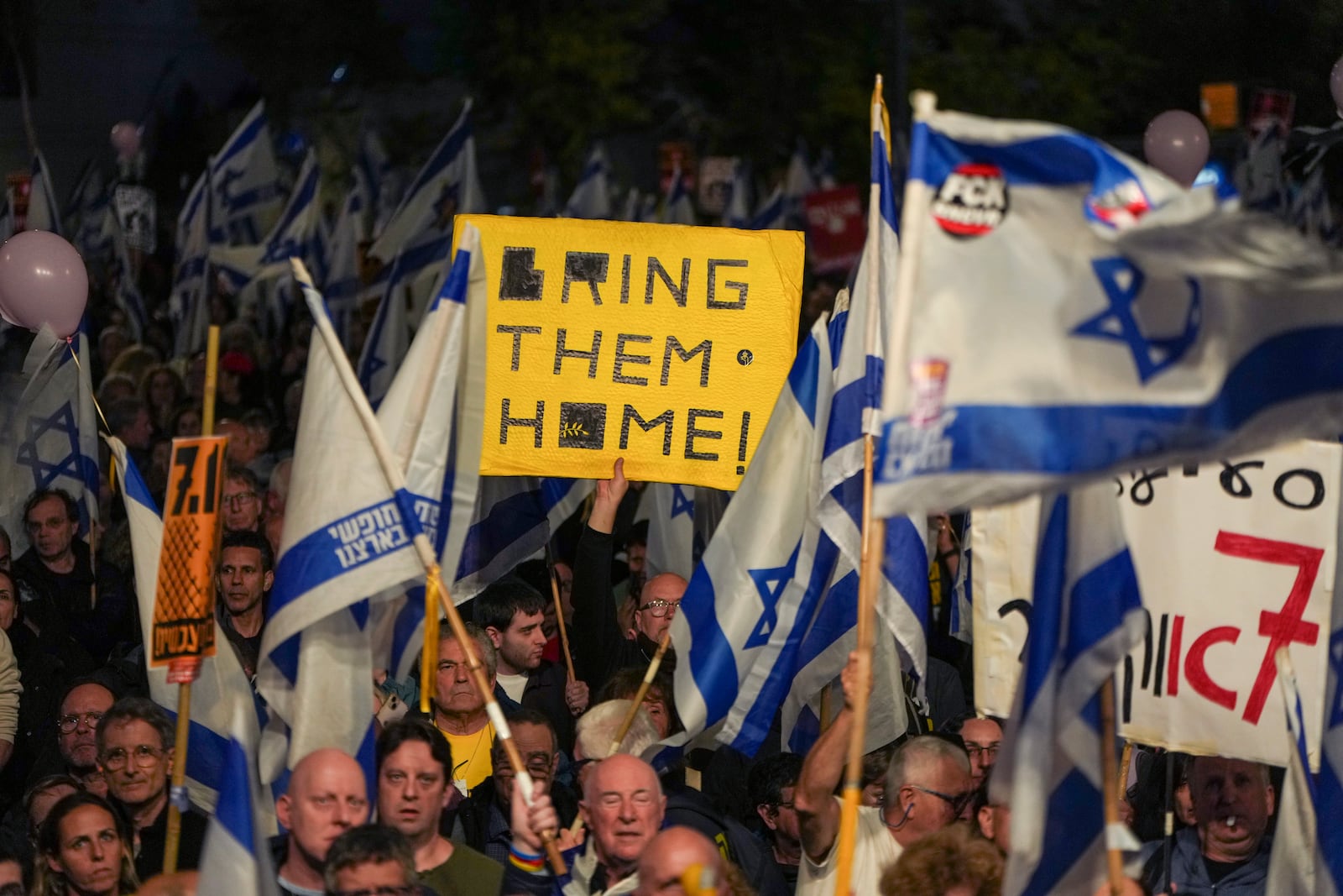 Israelis protest against Prime Minister Benjamin Netanyahu's government and call for the release of hostages held in the Gaza Strip by the Hamas militant group in Tel Aviv, Israel, Saturday, Dec. 21, 2024. (AP Photo/Ohad Zwigenberg)