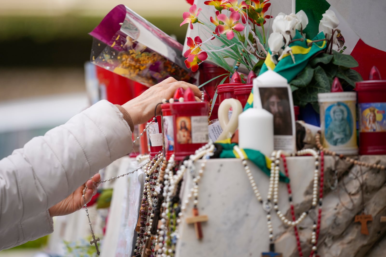 People pray for Pope Francis in front of the Agostino Gemelli Polyclinic, in Rome, Thursday, March 13, 2025, where the Pontiff is hospitalized since Friday, Feb. 14. (AP Photo/Andrew Medichini)