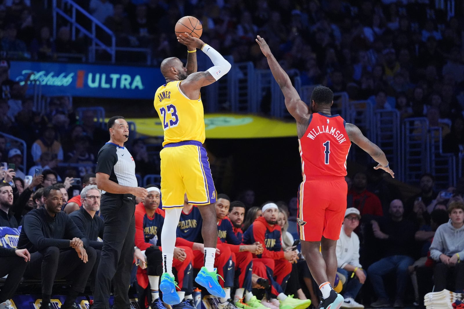 Los Angeles Lakers forward LeBron James, left, makes a 3-point basket over New Orleans Pelicans forward Zion Williamson (1) to go over the 50,000 career point mark during the first half of an NBA basketball game Tuesday, March 4, 2025, in Los Angeles. (AP Photo/Jae C. Hong)