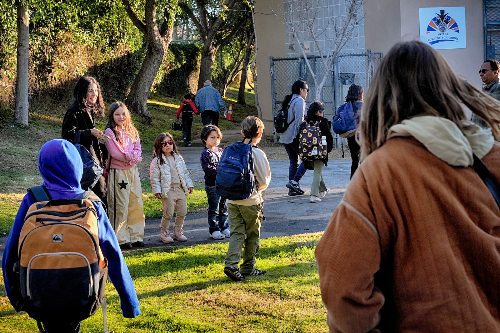 Palisades Charter Elementary School students and their parents arrive at their new school, the Brentwood Elementary Science Magnet school in the Brentwood section of Los Angeles on Wednesday, Jan. 15, 2025. (AP Photo/Richard Vogel)