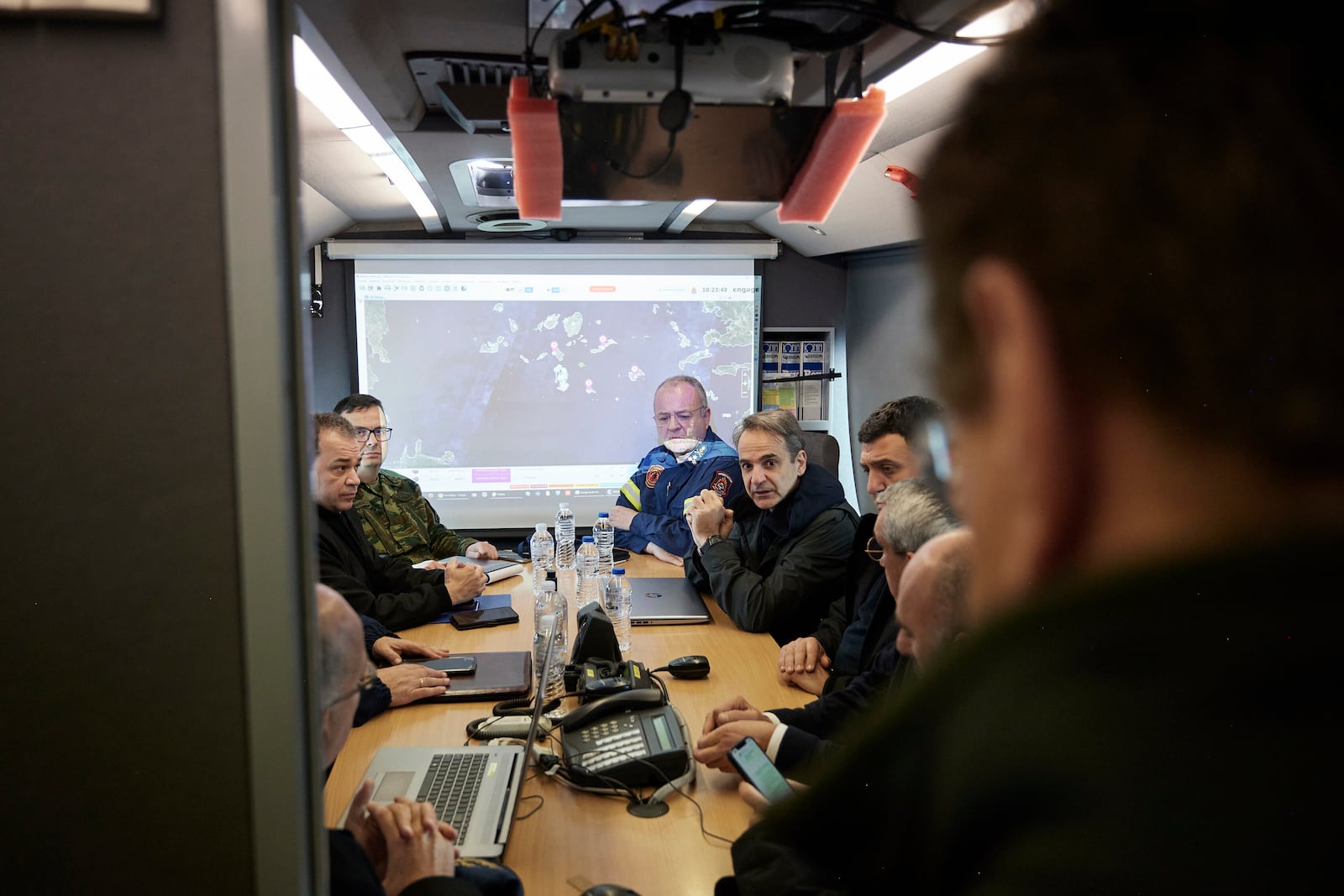 Greek Prime Minister Kyriakos Mitsotakis, center, gets an update during his visits at the temporary headquarters of emergency services, as Earthquakes are still rattling Greece's volcanic island of Santorini, on Friday, Feb. 7, 2025. (Dimitris Papamitsos/Greek Prime Minister's Office via AP)