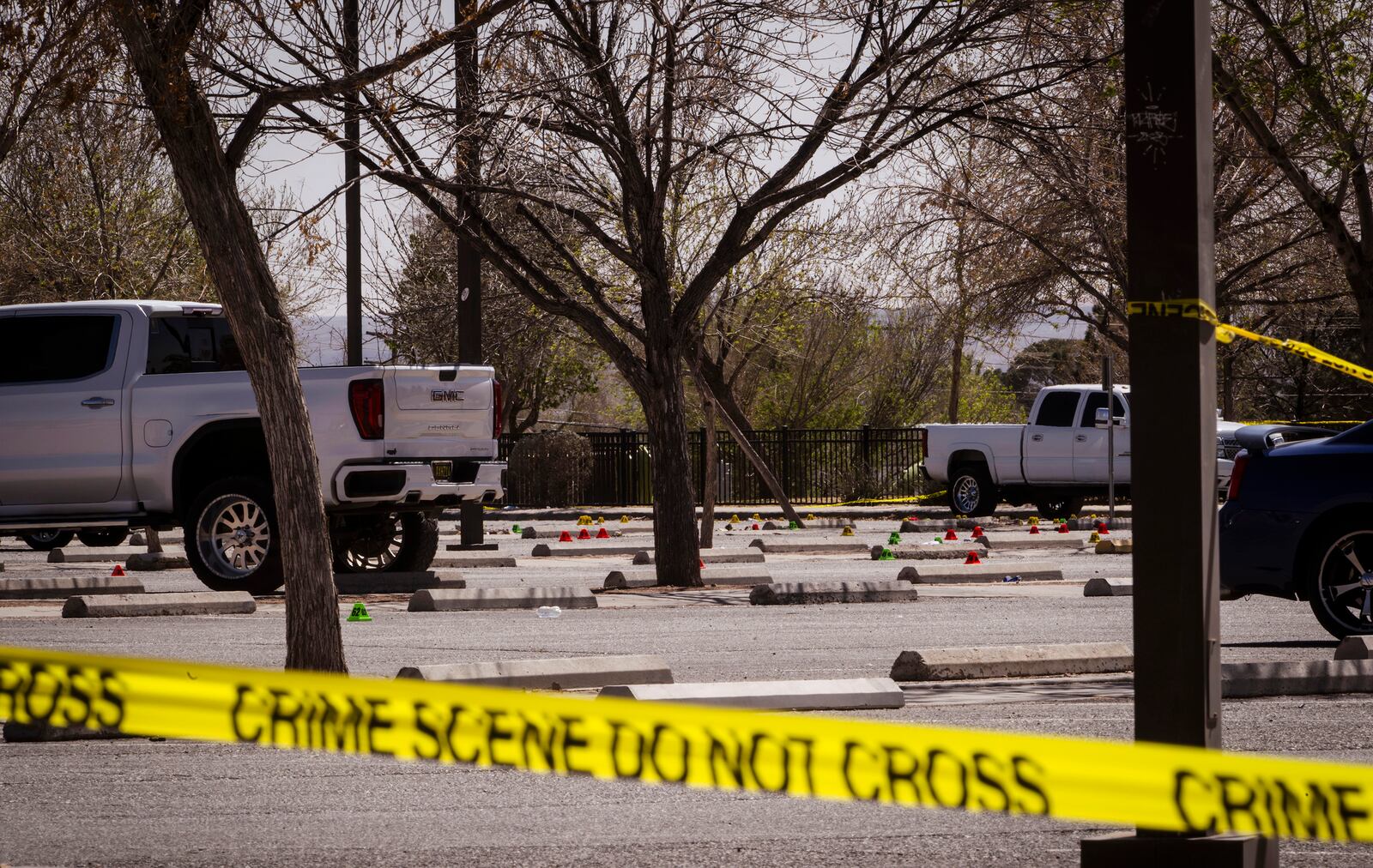 Evidence markers are shown in the parking lot at Young Park after Friday night's fatal shooting in Las Cruces, N.M., on Saturday, March 22, 2025. (Chancey Bush/The Albuquerque Journal via AP)