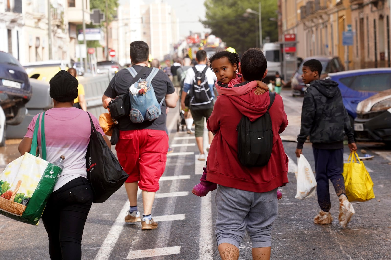 People walk along the road after leaving their homes flooded by the floods in Valencia, Spain on Wednesday, Oct. 30, 2024. (AP Photo/Alberto Saiz)