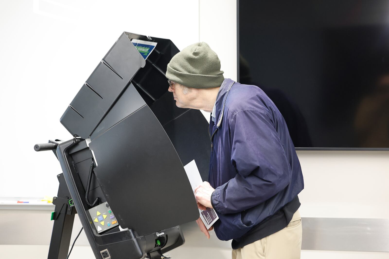 A man looks over a ballot during early voting in Waukesha, Wis., Tuesday, March 18, 2025. (AP Photo/Jeffrey Phelps)