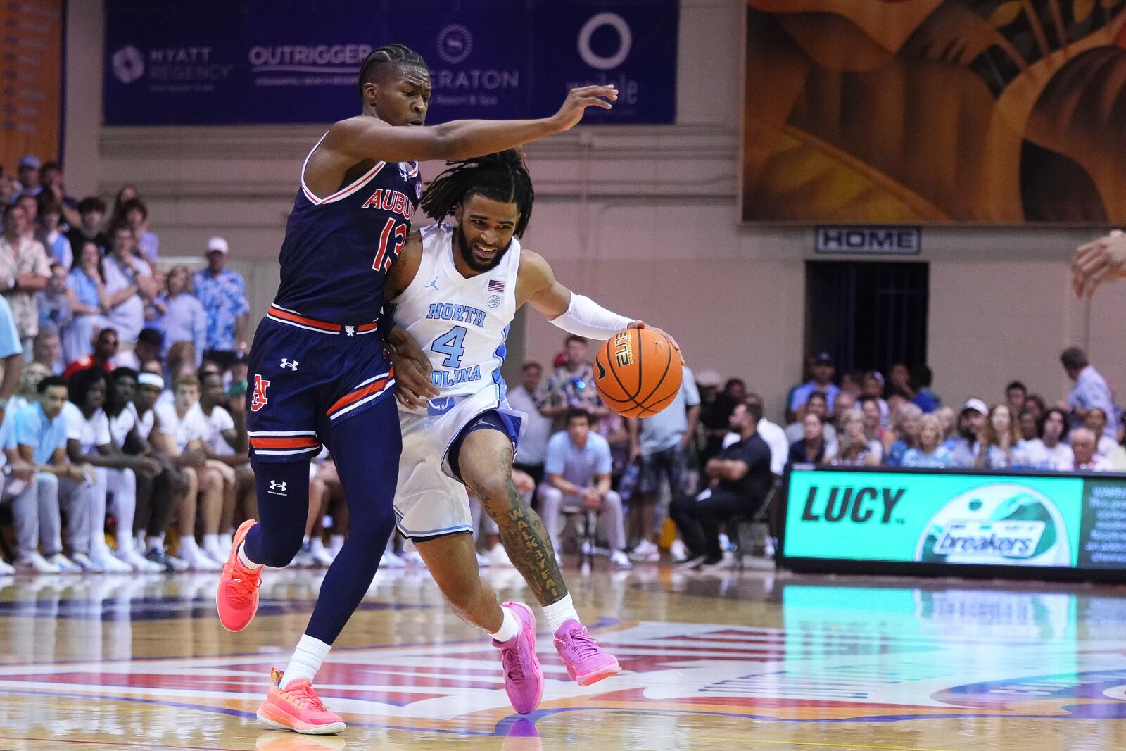 North Carolina guard RJ Davis (4) drives against Auburn guard Miles Kelly, left, during the first half of an NCAA college basketball game at the Maui Invitational Tuesday, Nov. 26, 2024, in Lahaina, Hawaii. (AP Photo/Lindsey Wasson)