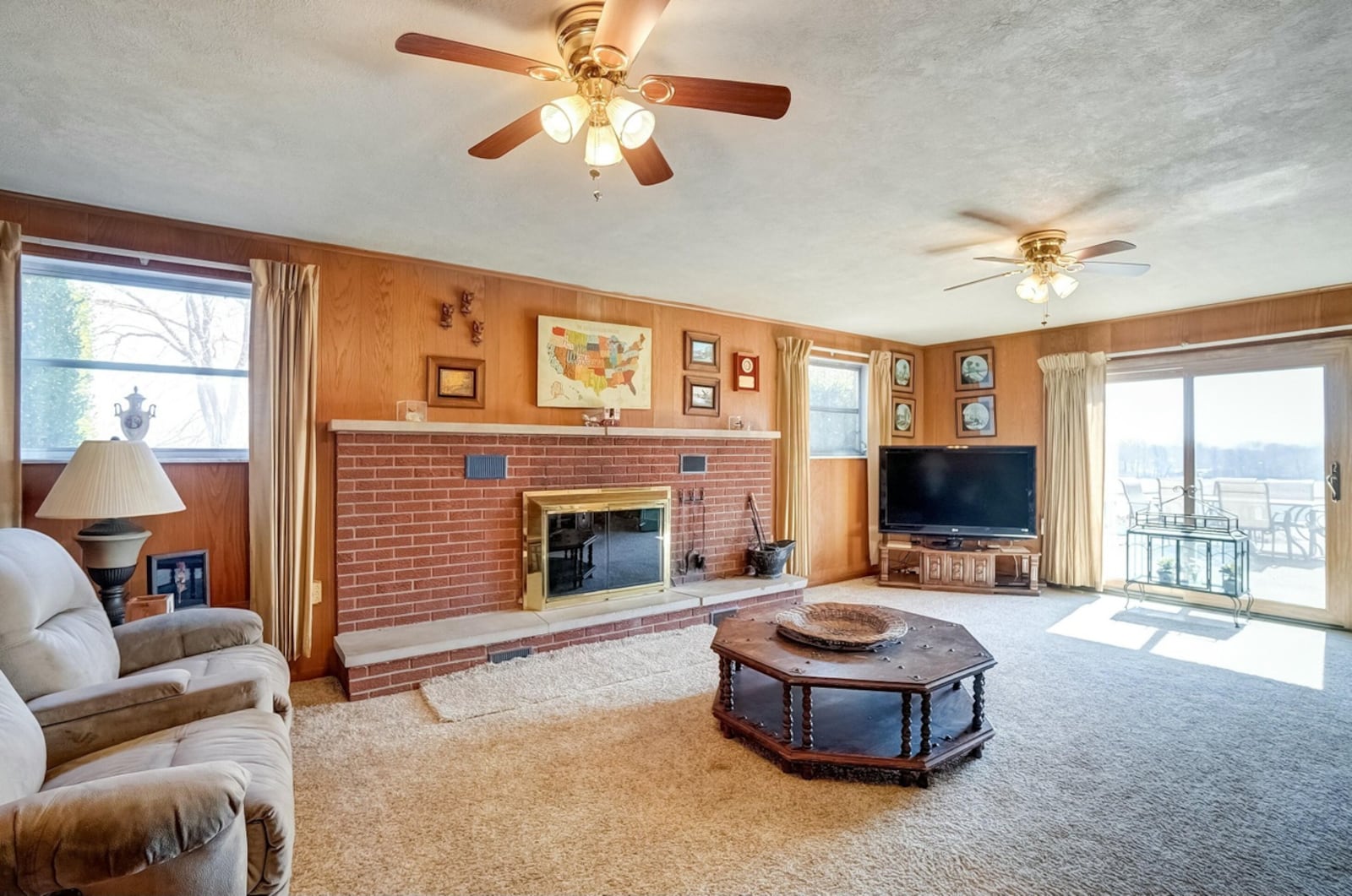 the lower level family room has a wood burning fireplace, carpeting and walks out to the patio and inground pool.