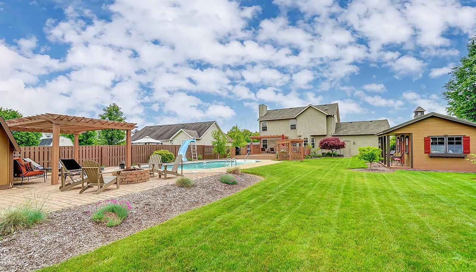 The rear yard is fully fenced and has composite decking, paver and stamped concrete patios, an inground pool with slide, three wood pergolas – one with swing, a shed and a round brick firepit. CONTRIBUTED PHOTO