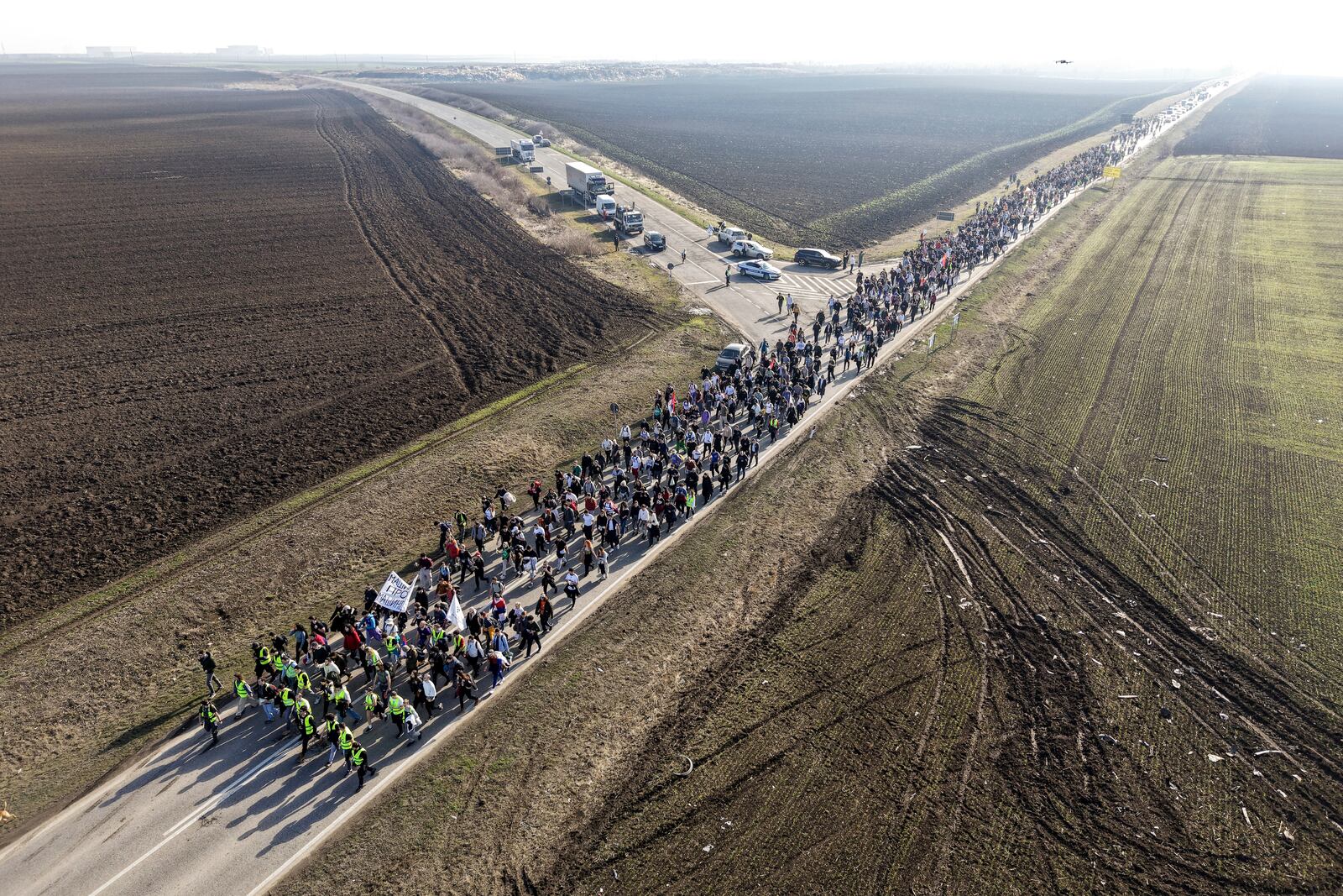 Students march trough the fields in northern Serbia as they protest over the collapse of a concrete canopy that killed 15 people more than two months ago, in Indjija, Serbia, Friday, Jan. 31, 2025. (AP Photo/Armin Durgut)