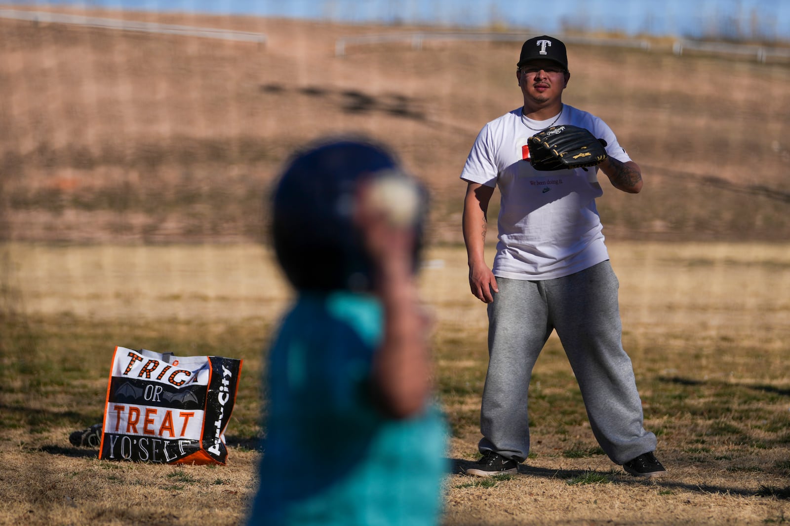 Dylan Cruz, 28, works on baseball batting skills with his son Jeremyah Cruz, 9, at Coleman Park Sunday, Feb. 23, 2025, in Brownfield, Texas. (AP Photo/Julio Cortez)