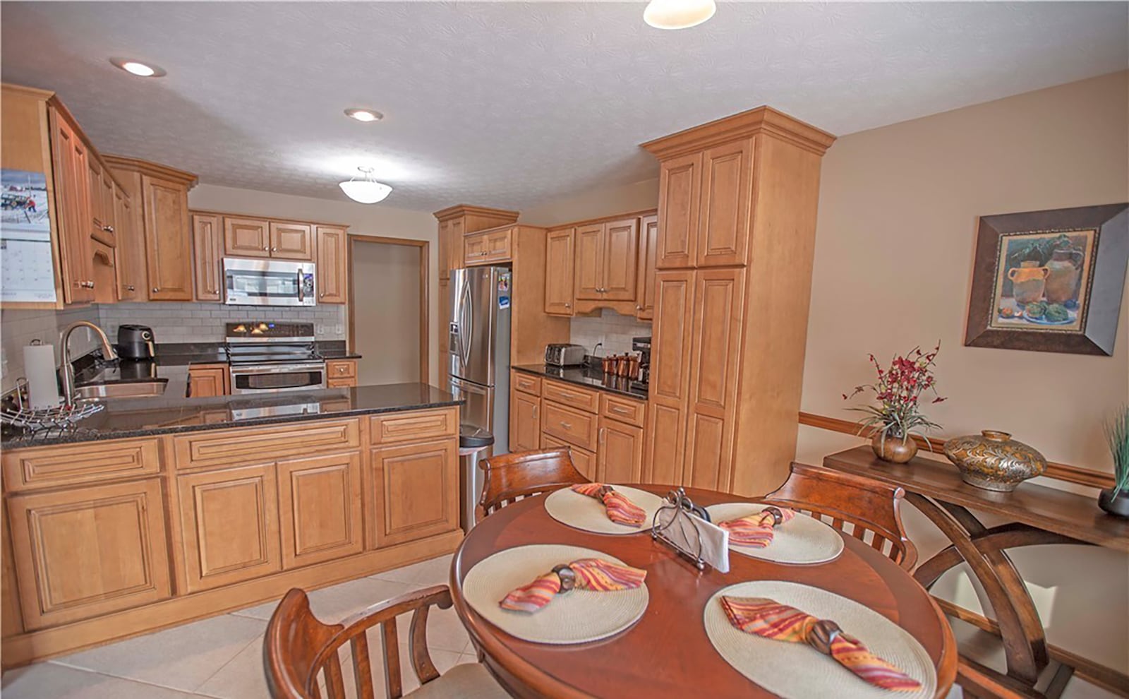 The eat in kitchen has wood cabinets, granite countertops, tile backsplash and updated appliances.