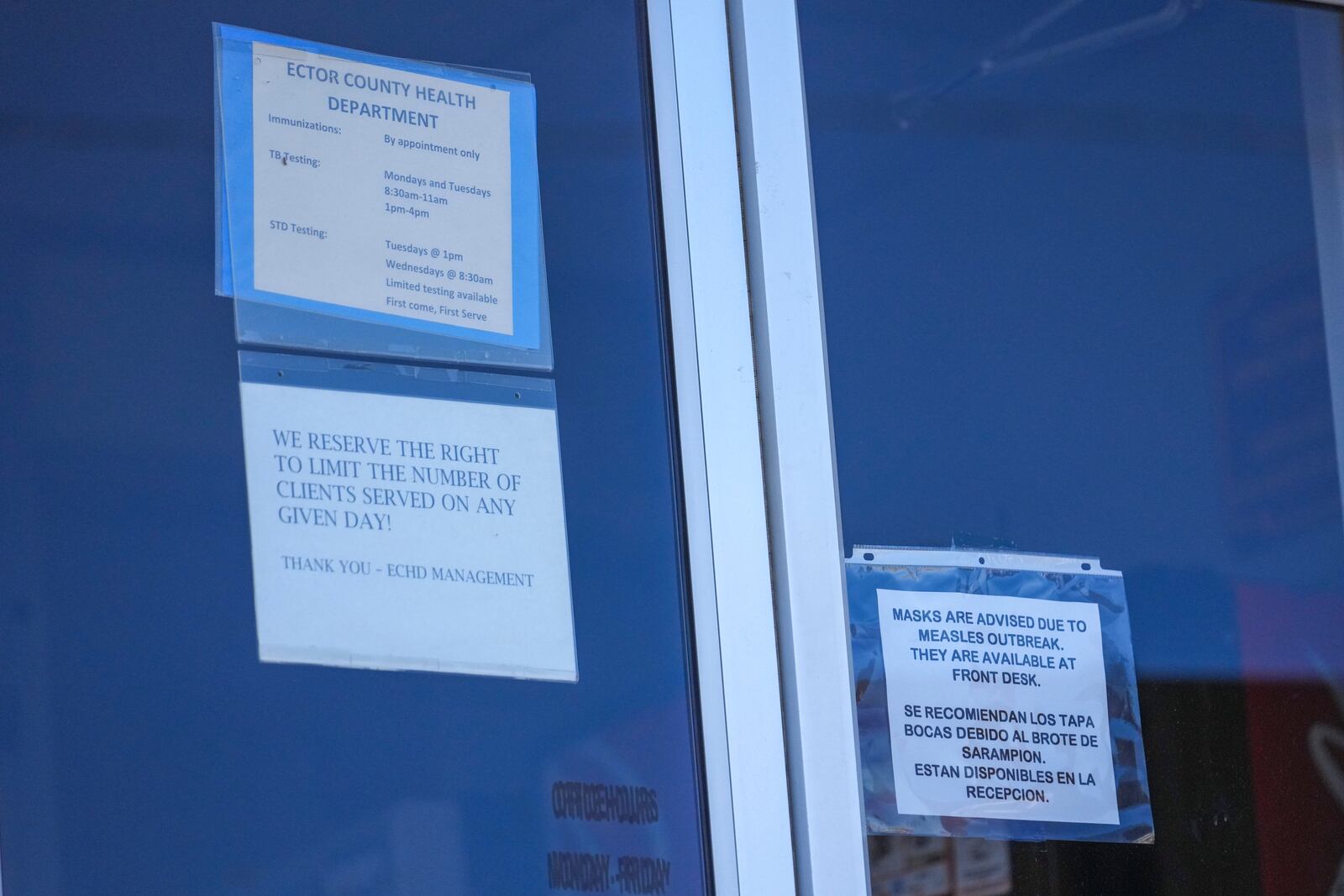 A sign asking patients of a mask requirement to prevent the spread of measles is seen on the door of the Ector County Health Department Monday, Feb. 24, 2025, in Odessa, Texas. (AP Photo/Julio Cortez)