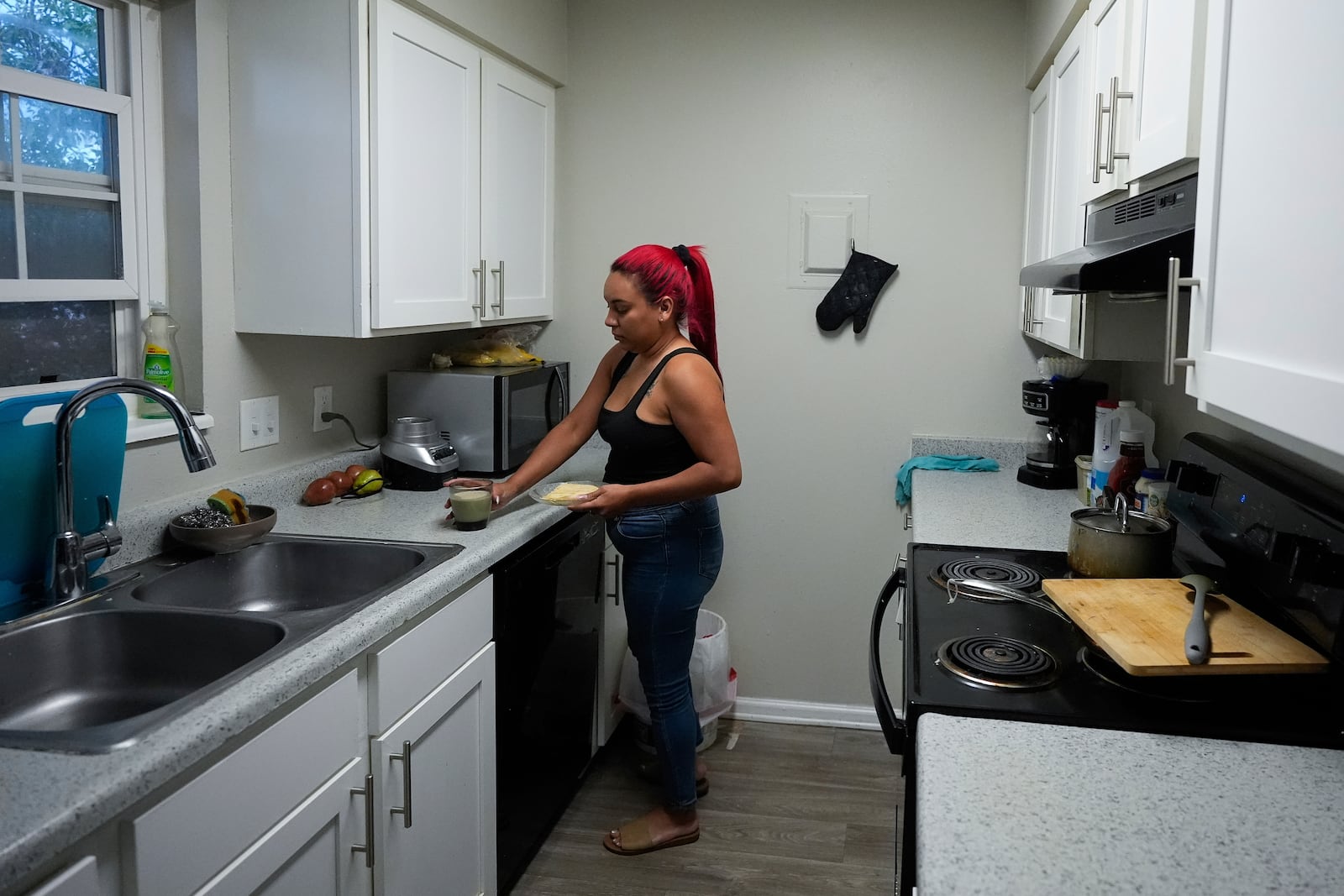 Gabriela Ramírez prepares breakfast for her son Thursday, Aug. 29, 2024, in Aurora, Colo. (AP Photo/Godofredo A. Vásquez)