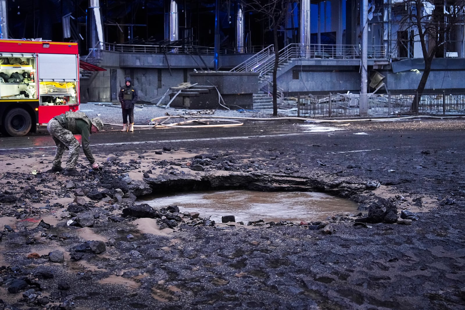 A Ukrainian serviceman collects evidence following a Russian missile attack in Kyiv, Ukraine, Saturday, Jan. 18, 2025. (AP Photo/Efrem Lukatsky)