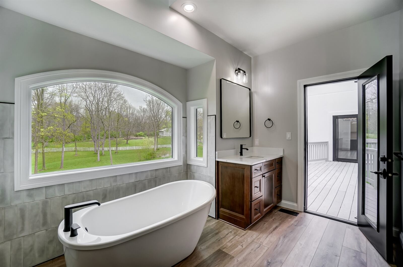 The primary bathroom has a spa appeal with a free-standing soak tub that offers views of the pond and woods.