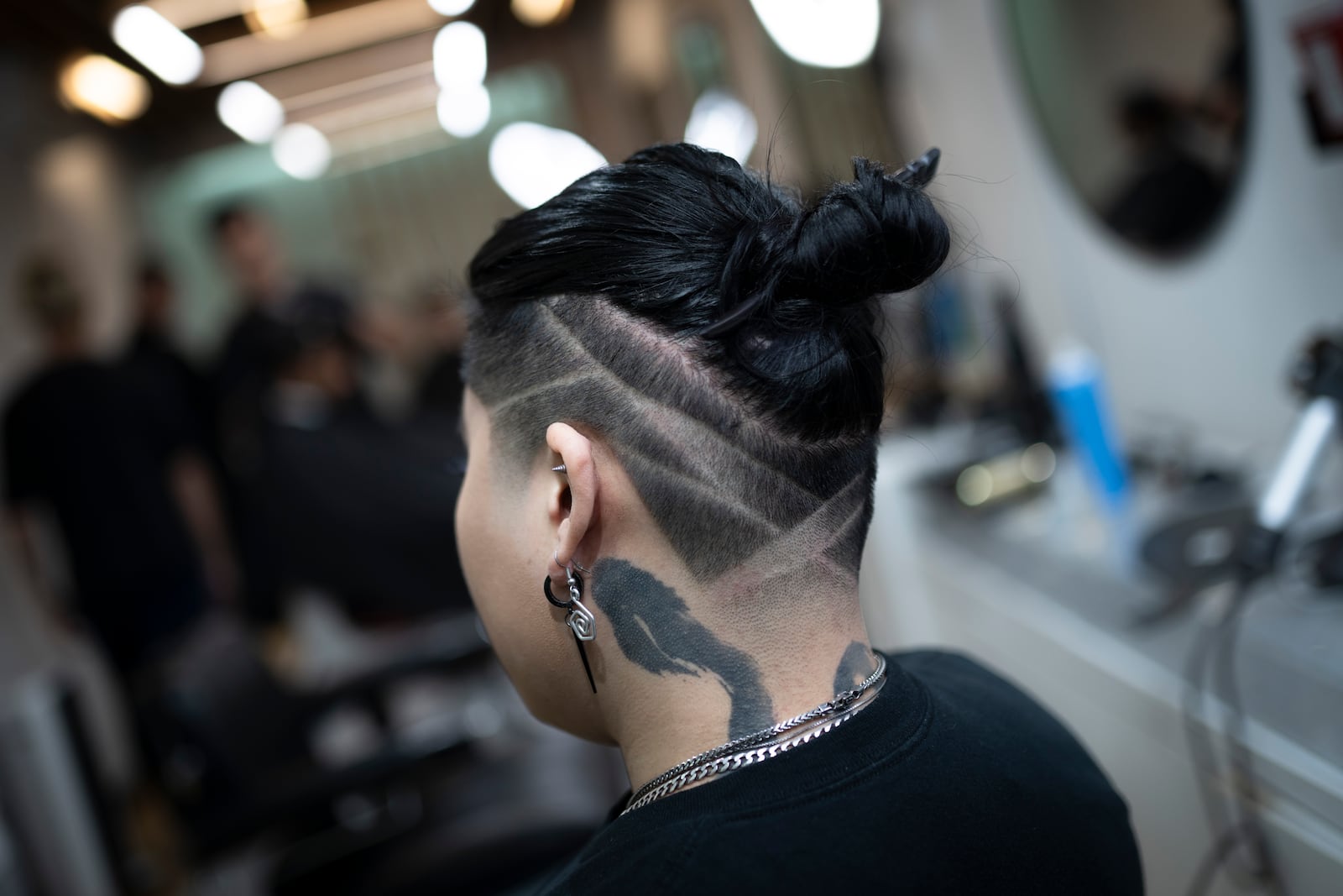 A client is checked for final touchups after a styling at 12 Pell, a local barbershop in Manhattan's Chinatown, Thursday, Jan. 25, 2024, in New York. The clients at the personal care and grooming store aren't just coming from the neighborhood. They're coming from around the metro region and even further, making appointments a month out. (AP Photo/John Minchillo)