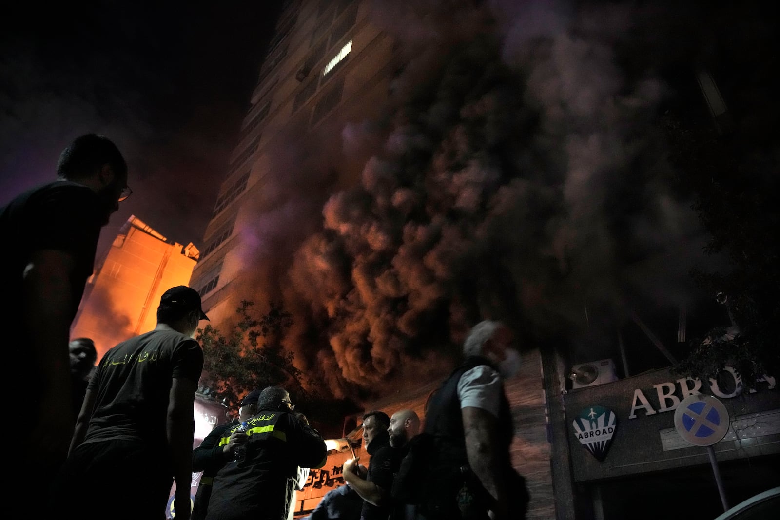 Firefighters and rescuers gather outside a computer shop hit in an Israeli airstrike in central Beirut, Sunday, Nov. 17, 2024. (AP Photo/Bilal Hussein)