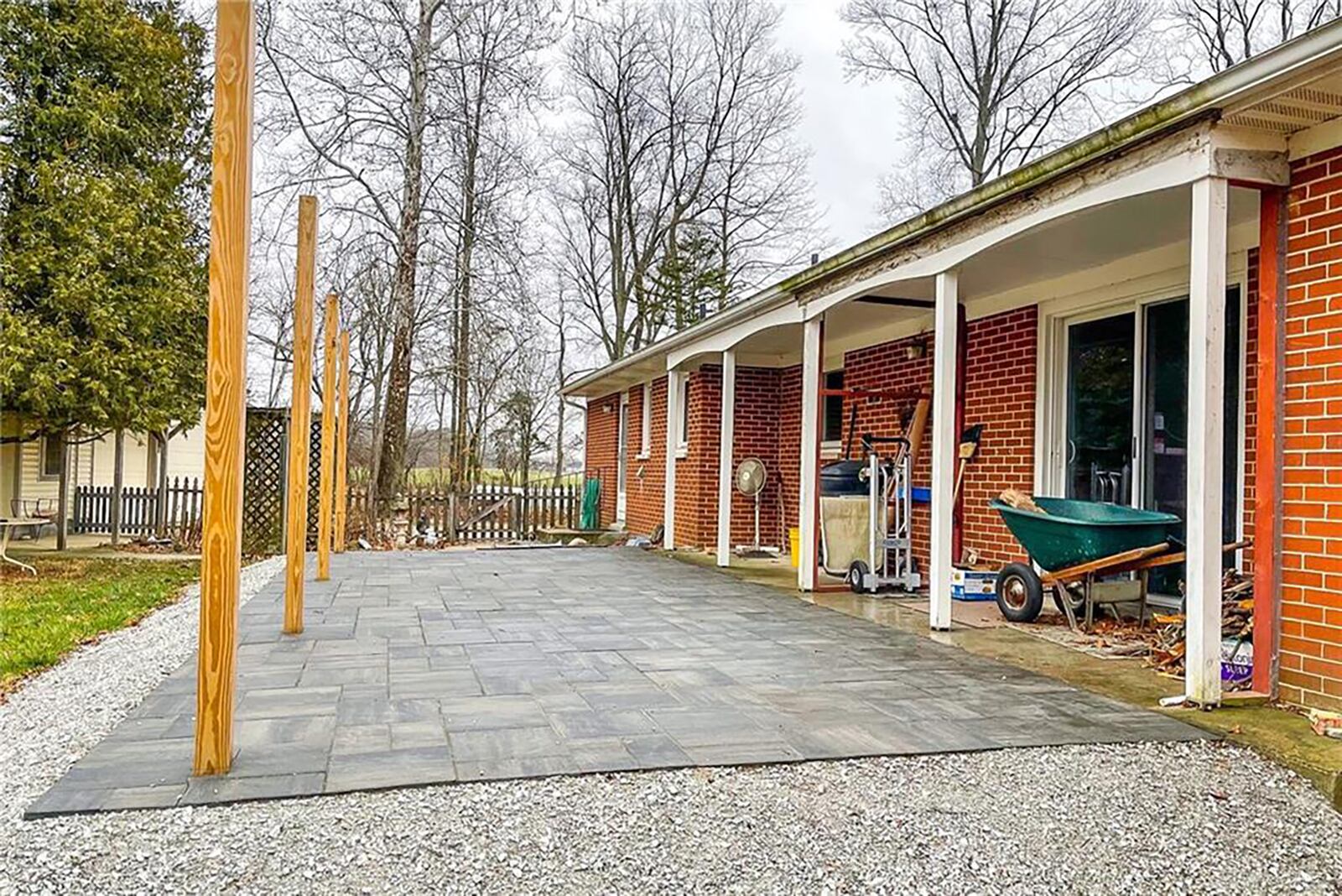 The rear of the home has a new concrete paver patio with wood beams to support a future cover, a partially fenced backyard with wood and wire fencing and a 36' x 40' pole barn.