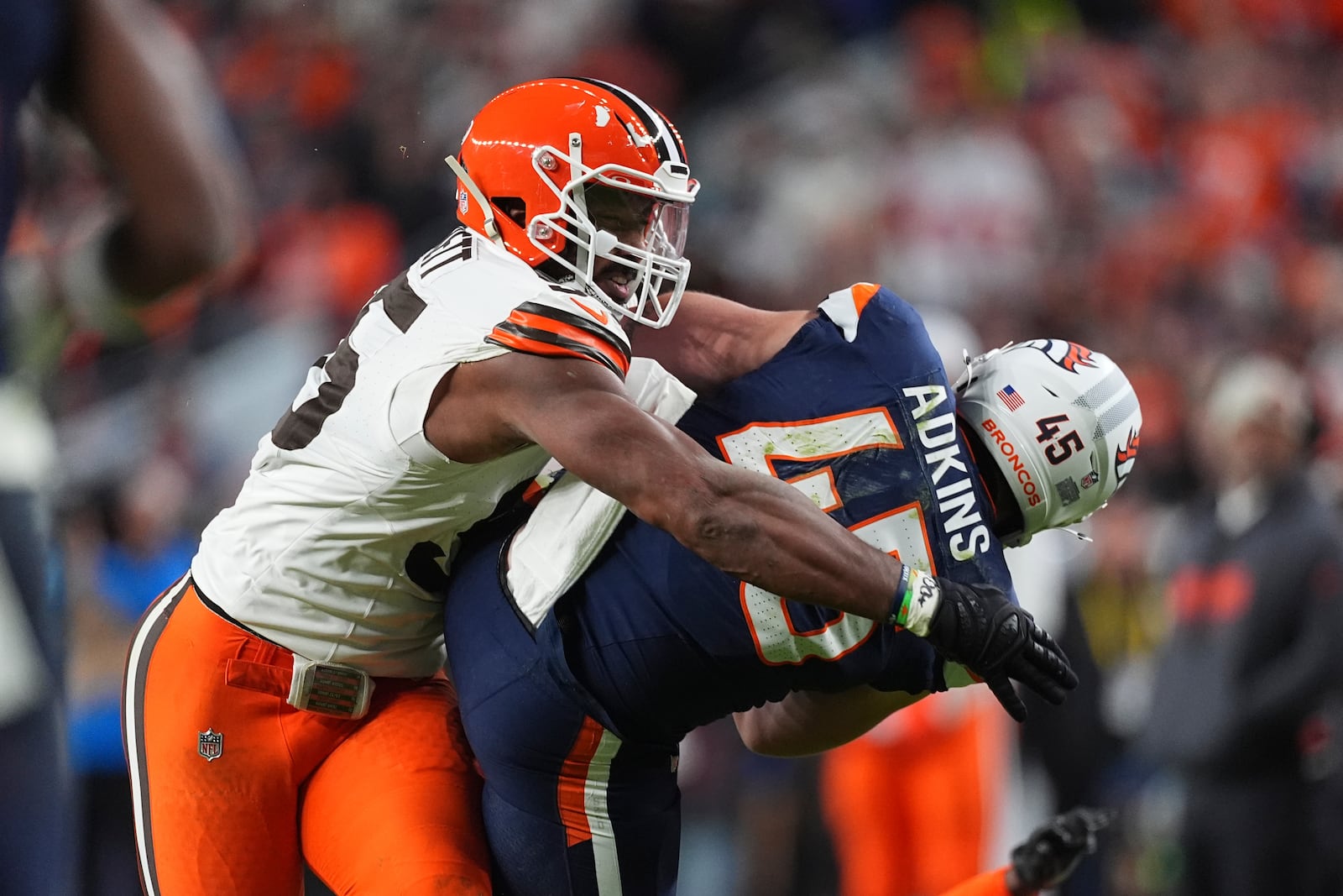 Denver Broncos tight end Nate Adkins (45) is tackled by Cleveland Browns defensive end Myles Garrett (95) after a reception during the first half of an NFL football game, Monday, Dec. 2, 2024, in Denver. (AP Photo/David Zalubowski)